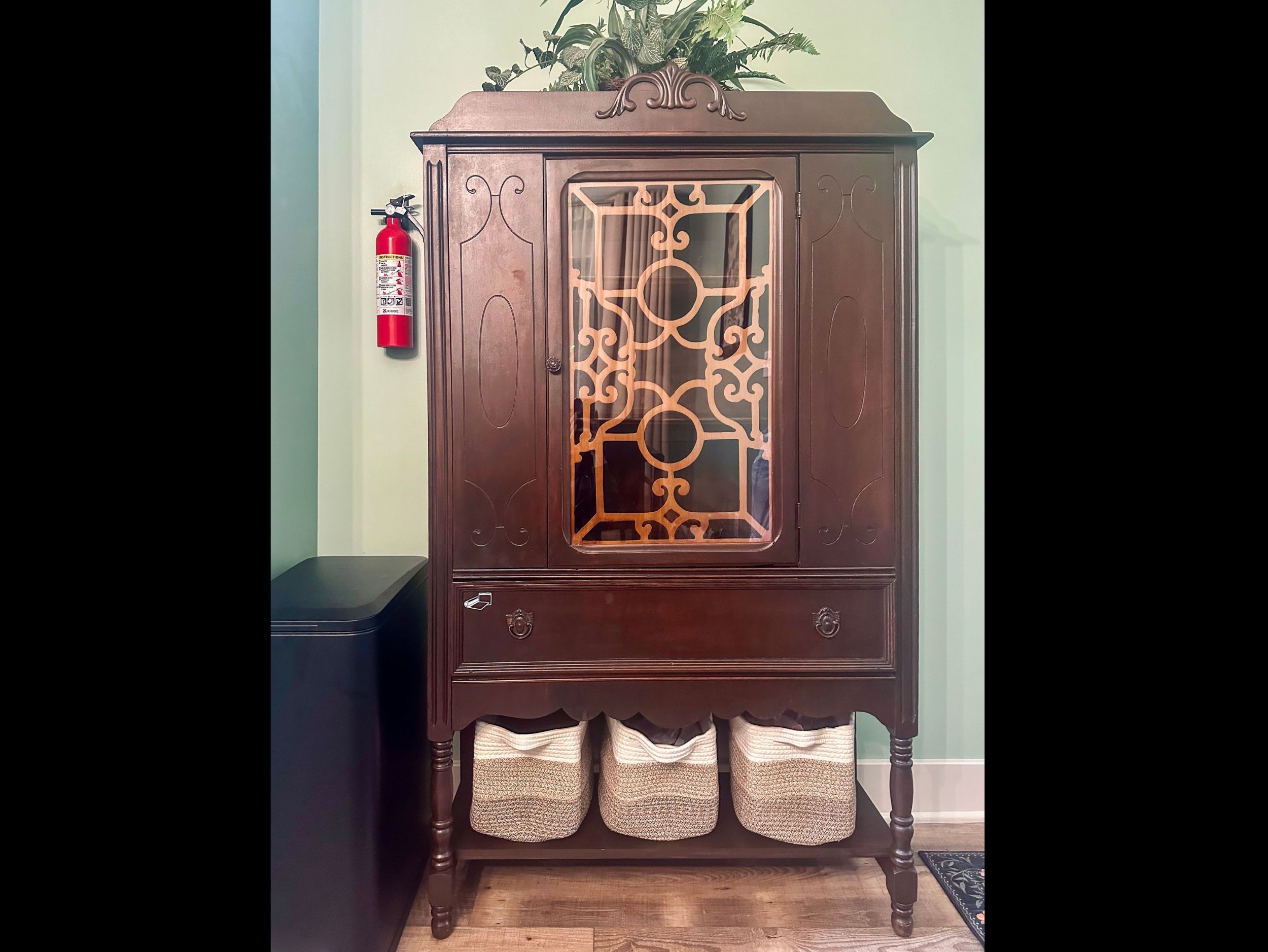 Pantry cabinet offering additional storage alongside a conveniently placed trash receptacle to keep the kitchen organized.