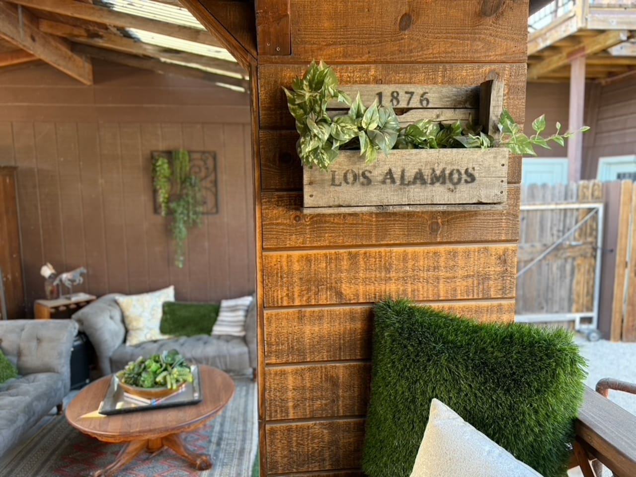 By day, the covered porch offers shaded corners for coffee, reading and conversation. After sunset, café lights and thoughtful uplighting transform the interconnected lounges into a warm, glowing setting for dinner, drinks and long evenings together.