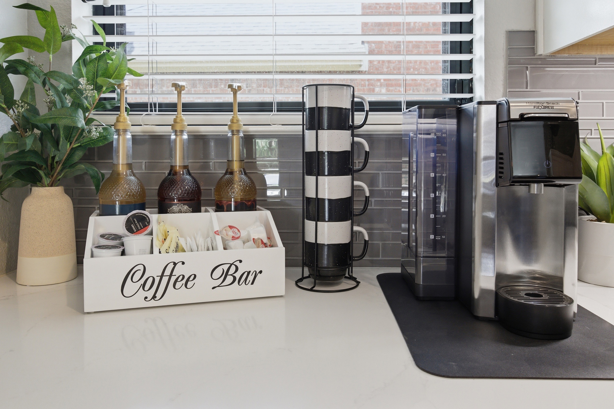 Dedicated Coffee Bar with the Hamilton Beach FlexBrew Coffee Maker, stocked with K-Cup pods and ready for ground coffee. Mugs, accessories, and a full morning setup included.
