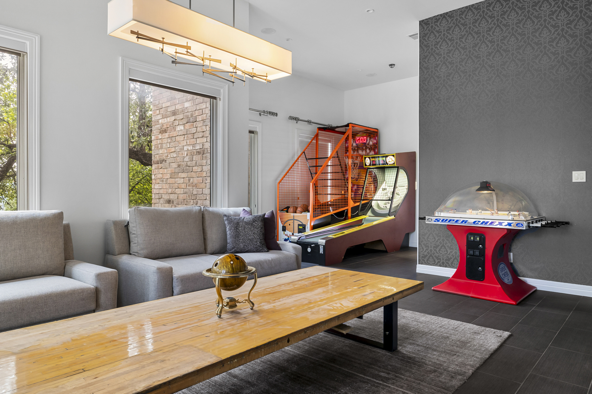 Game room / flex space of the pool with 2 pullouts, commercial arcade games, and banquet kitchen space.