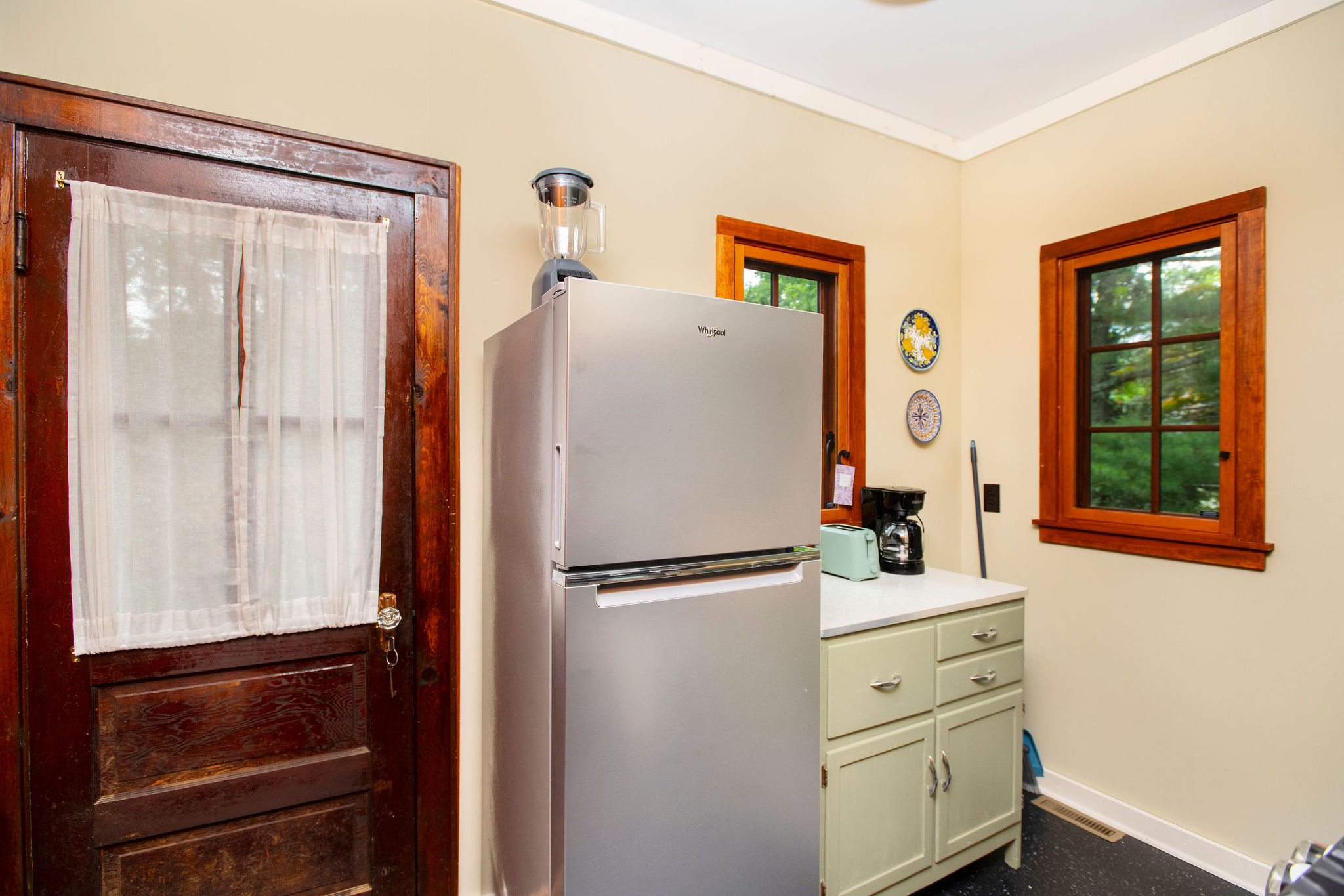 Bright kitchen with full-size stainless refrigerator and coffee maker