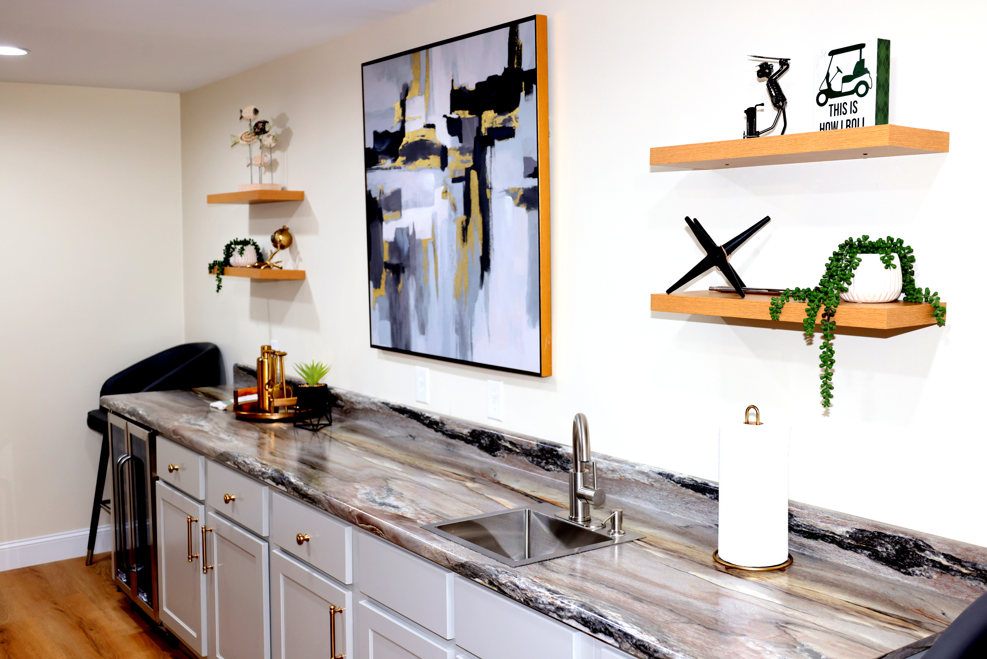 Beautiful entertainment bar with stone-look countertop, floating shelves, and designer detail