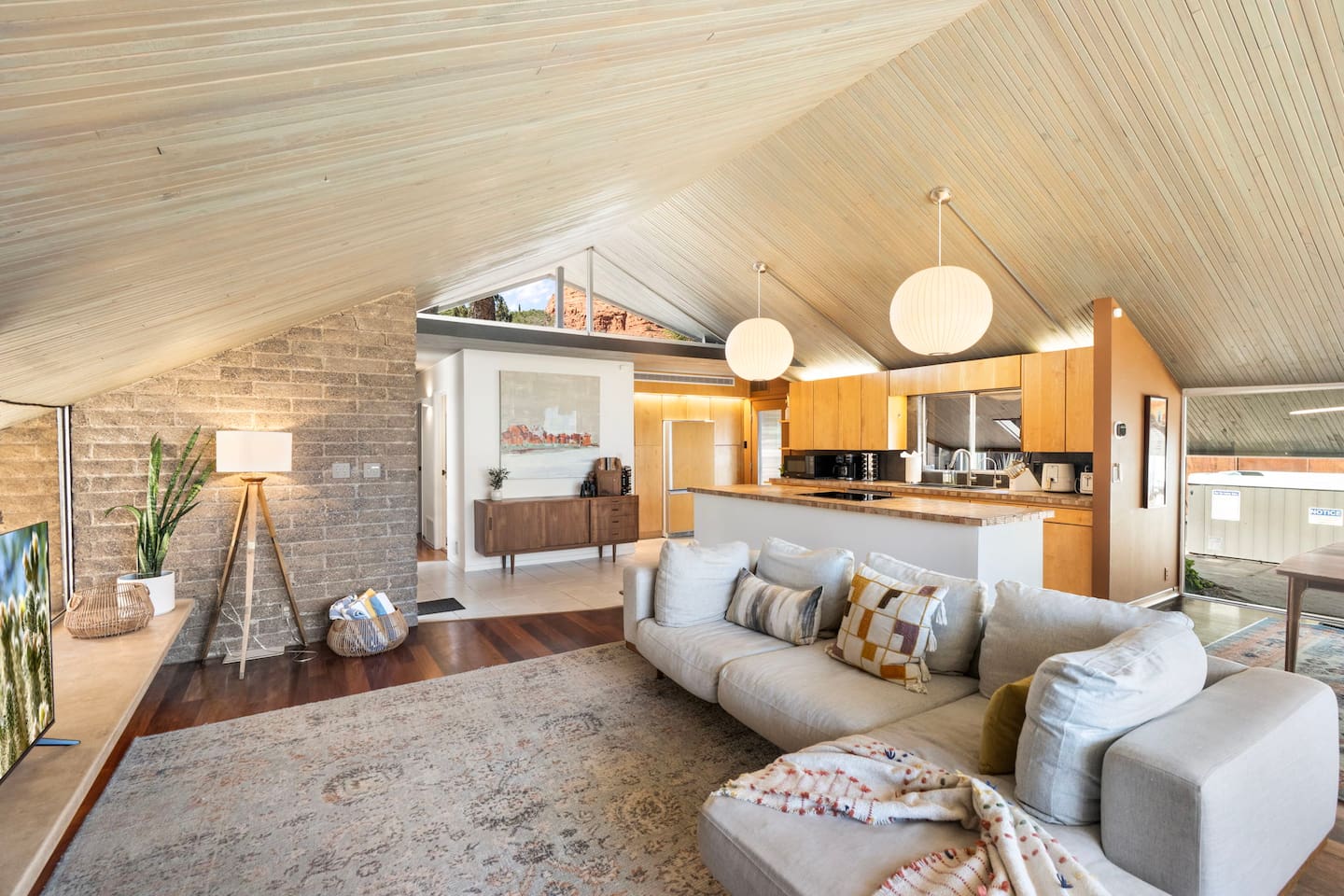 Spacious mid-century living area with soaring wood ceilings, warm finishes, and a bright open kitchen perfect for gathering.