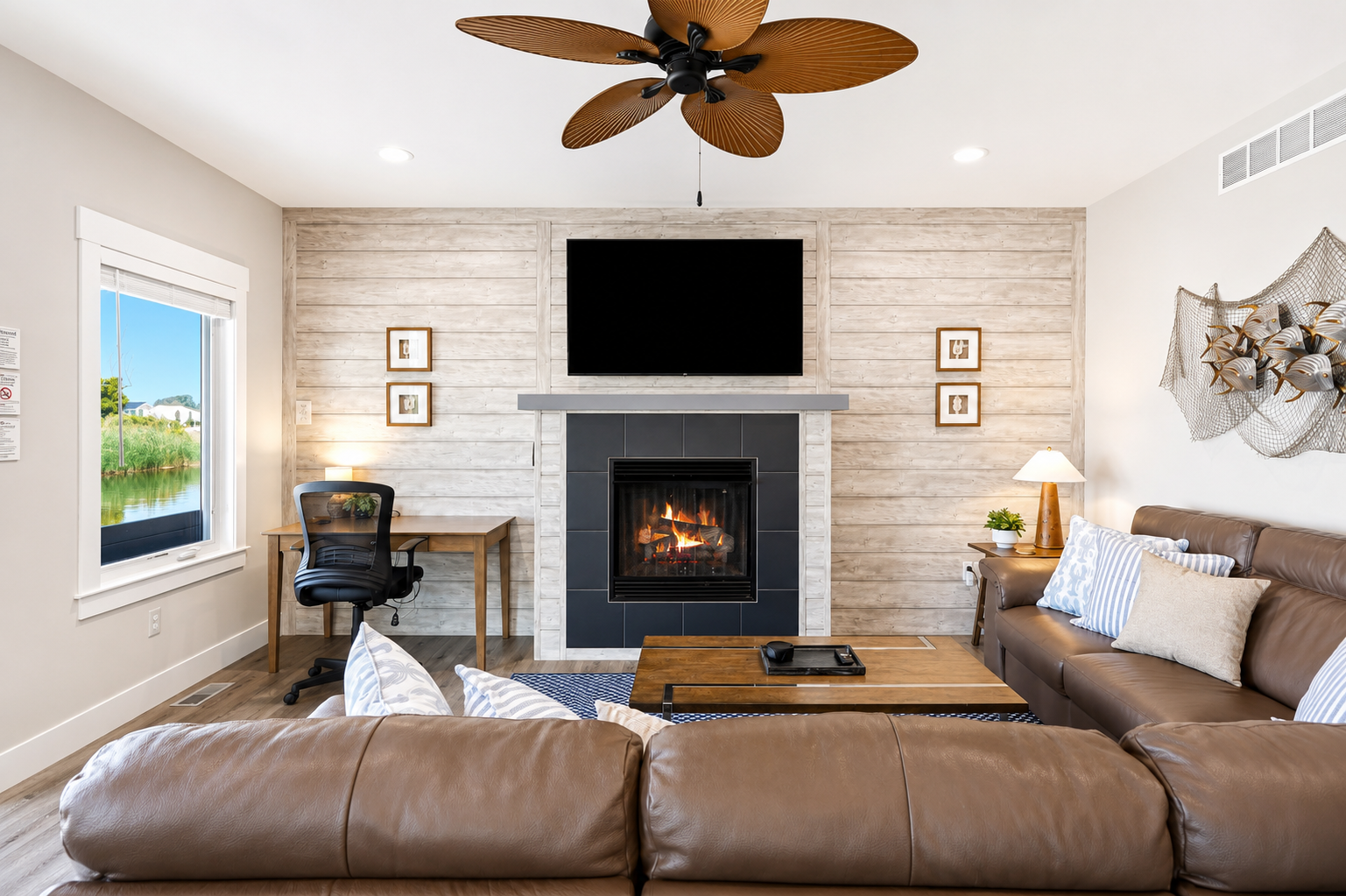 Relax in the heart of the home with a cozy fireplace, Smart TV, comfortable seating, dedicated workspace, and beautiful canal views just outside the patio doors.