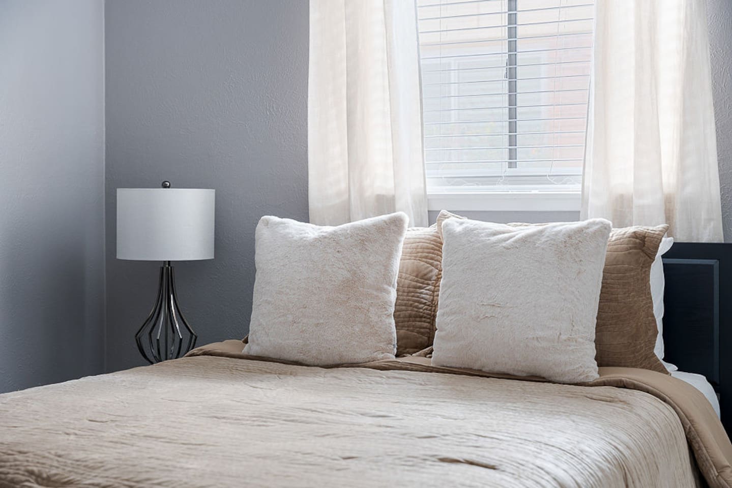 Find serenity in this beautiful bedroom featuring natural light, a comfy double bed, a nightstand and a lamp for your relaxation