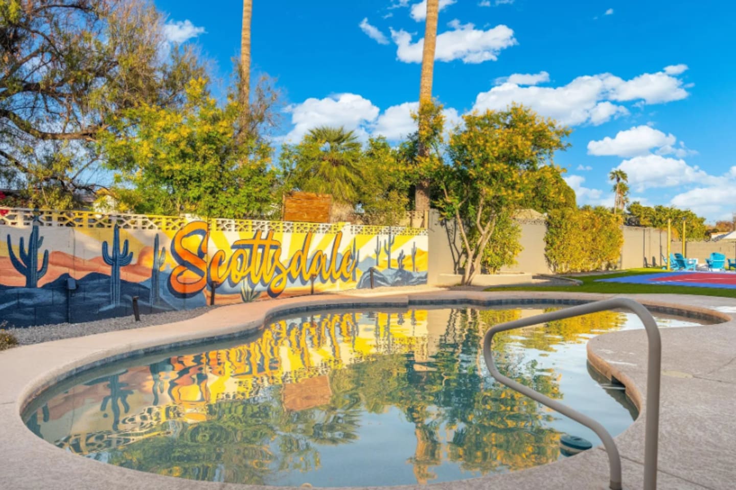 Sunlight dances across the pool by day, with the colorful Scottsdale mural reflected right on the surface.
