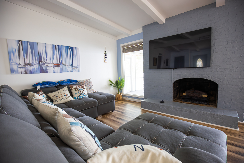 Gather in the living room with comfy seating, a big-screen TV, and a cozy fireplace for movie nights or relaxing after a day on the lake