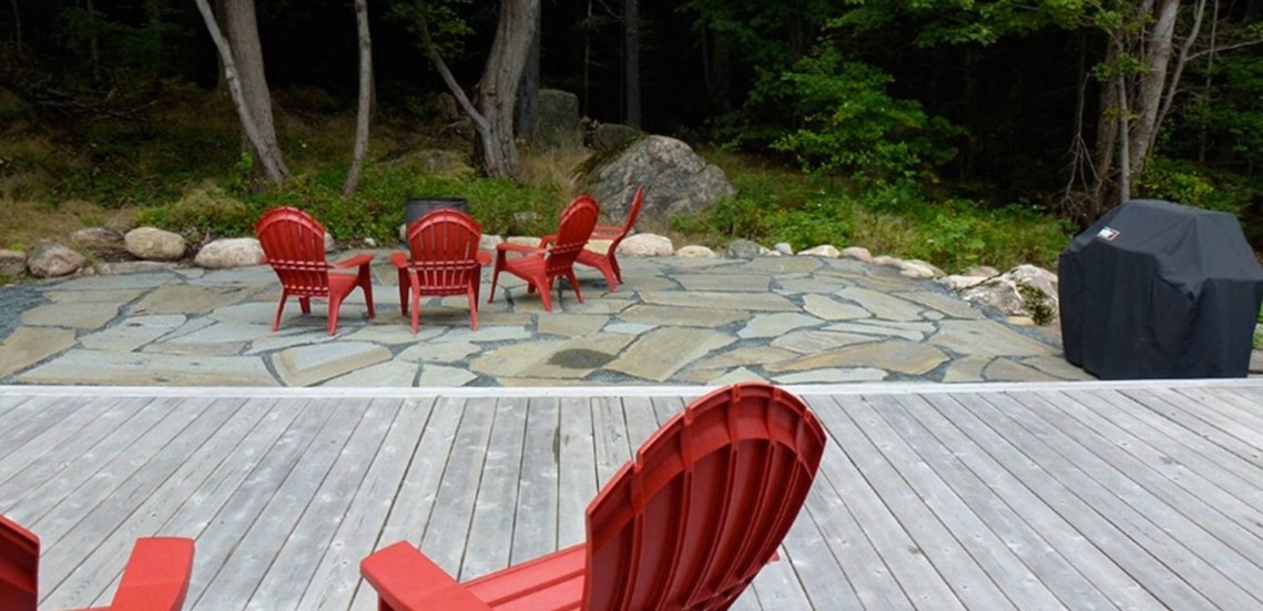 The expansive 33ft deck flows seamlessly into a custom stone fire pit area at the edge of the Acadia National Park woodlands. Equipped with a gas grill and Adirondack seating, this is the ultimate space for sunset dinners and stargazing.
