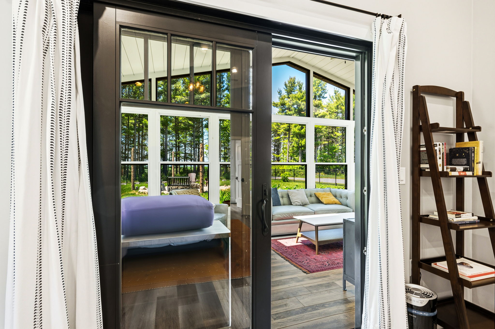 Sliding glass doors connect the home's interior to the tranquil sunroom retreat, filling the space with light and greenery.
