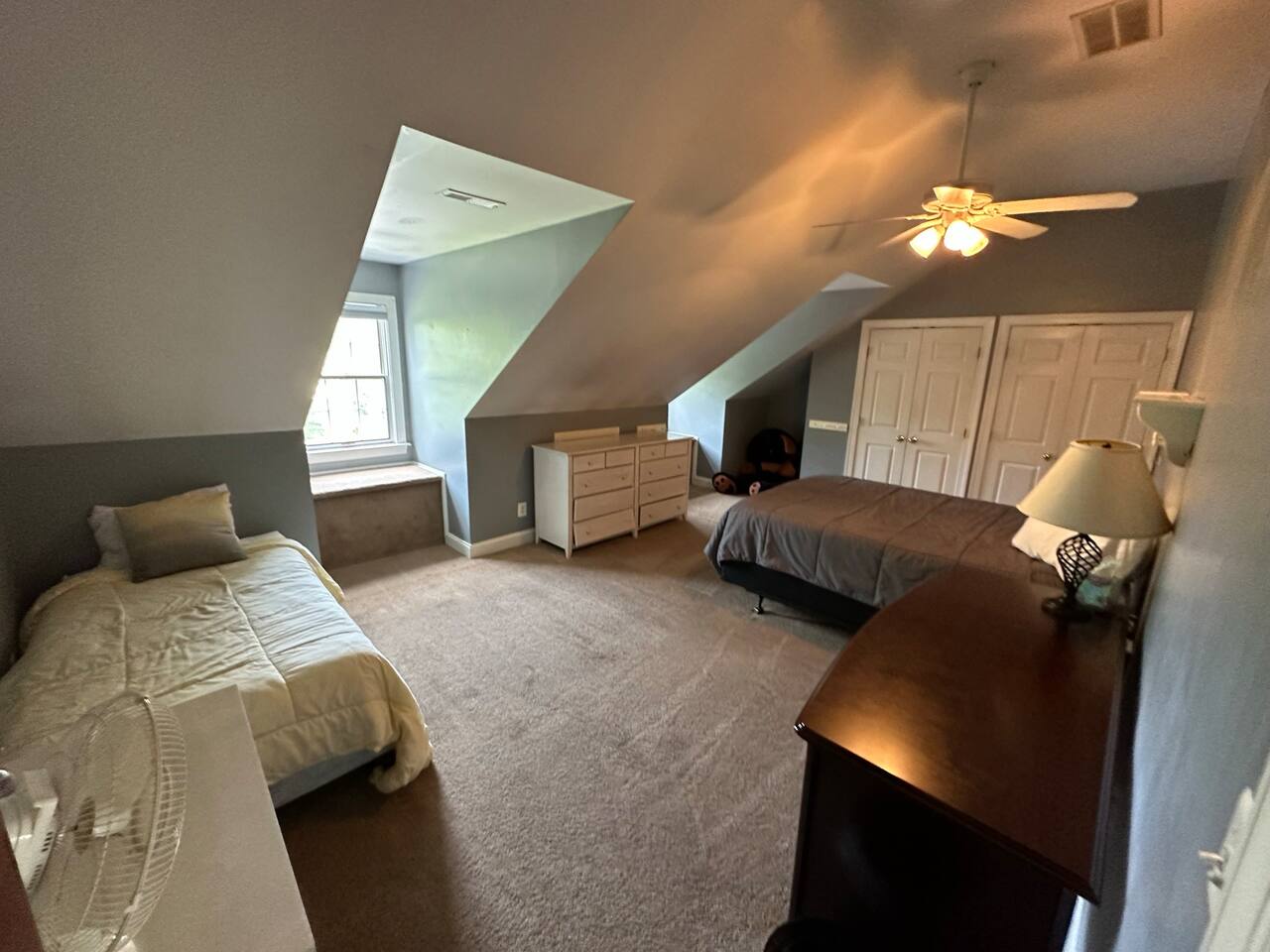 Bedroom 3 (BR3) with 1 Queen bed and one Twin bed. Has 2 dormers, 2 Closets, a Dresser, and a storage table.