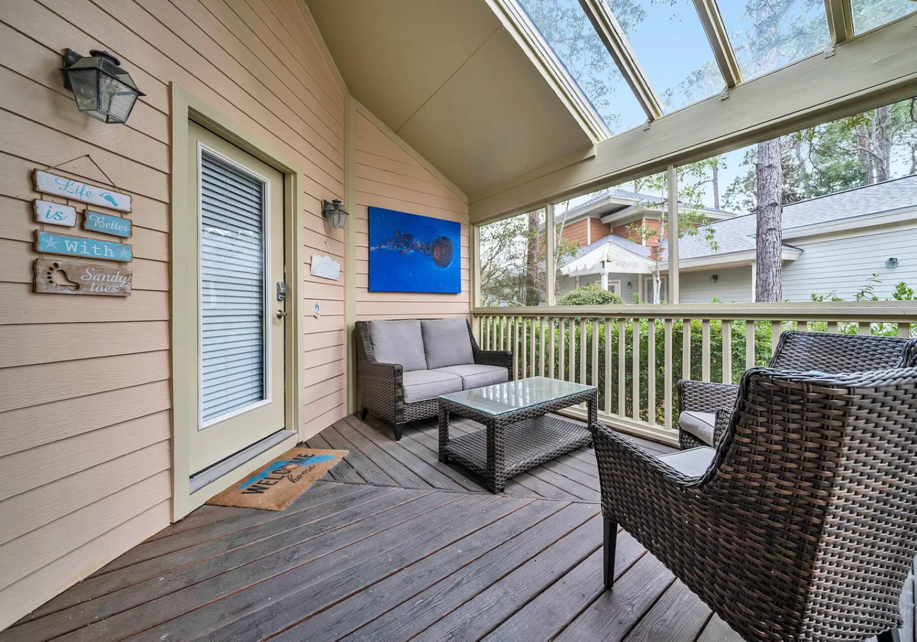 Cozy porch at Bayside Bliss. Relax in shaded wicker seating with views of lush dunes.
