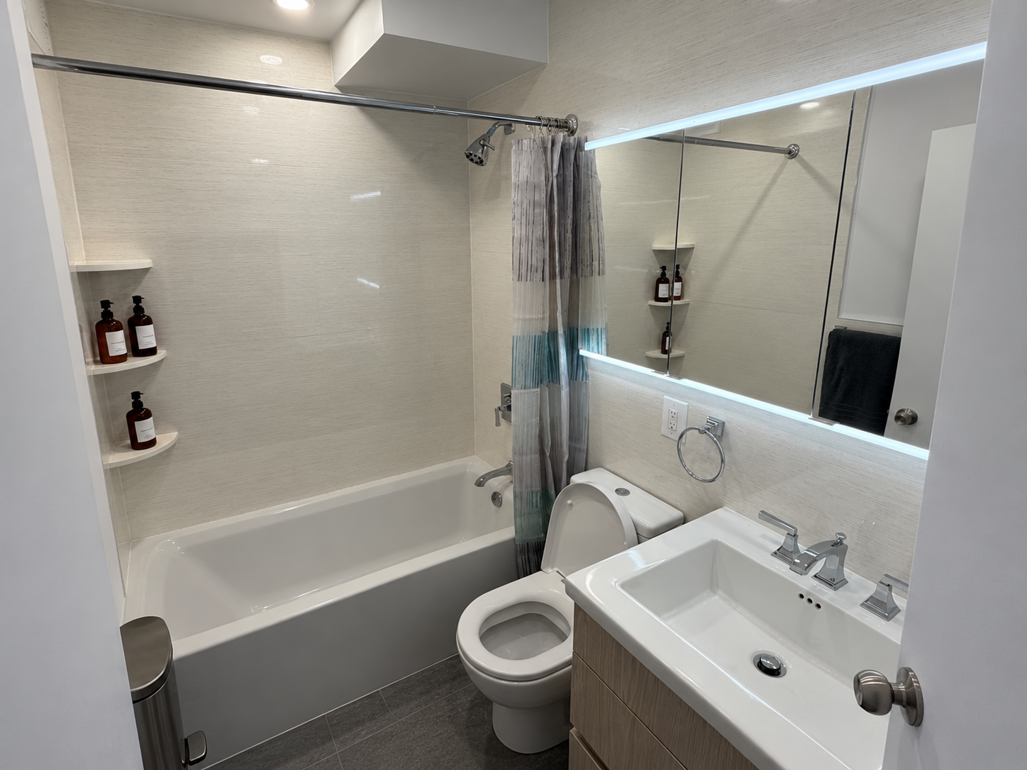 Modern full bathroom with LED-lit mirror and soaking tub — Little Italy NYC 2-bedroom apartment near SoHo and Nolita
