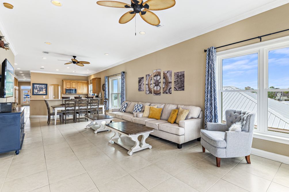 Open-concept living and dining area with abundant natural light and coastal furnishings