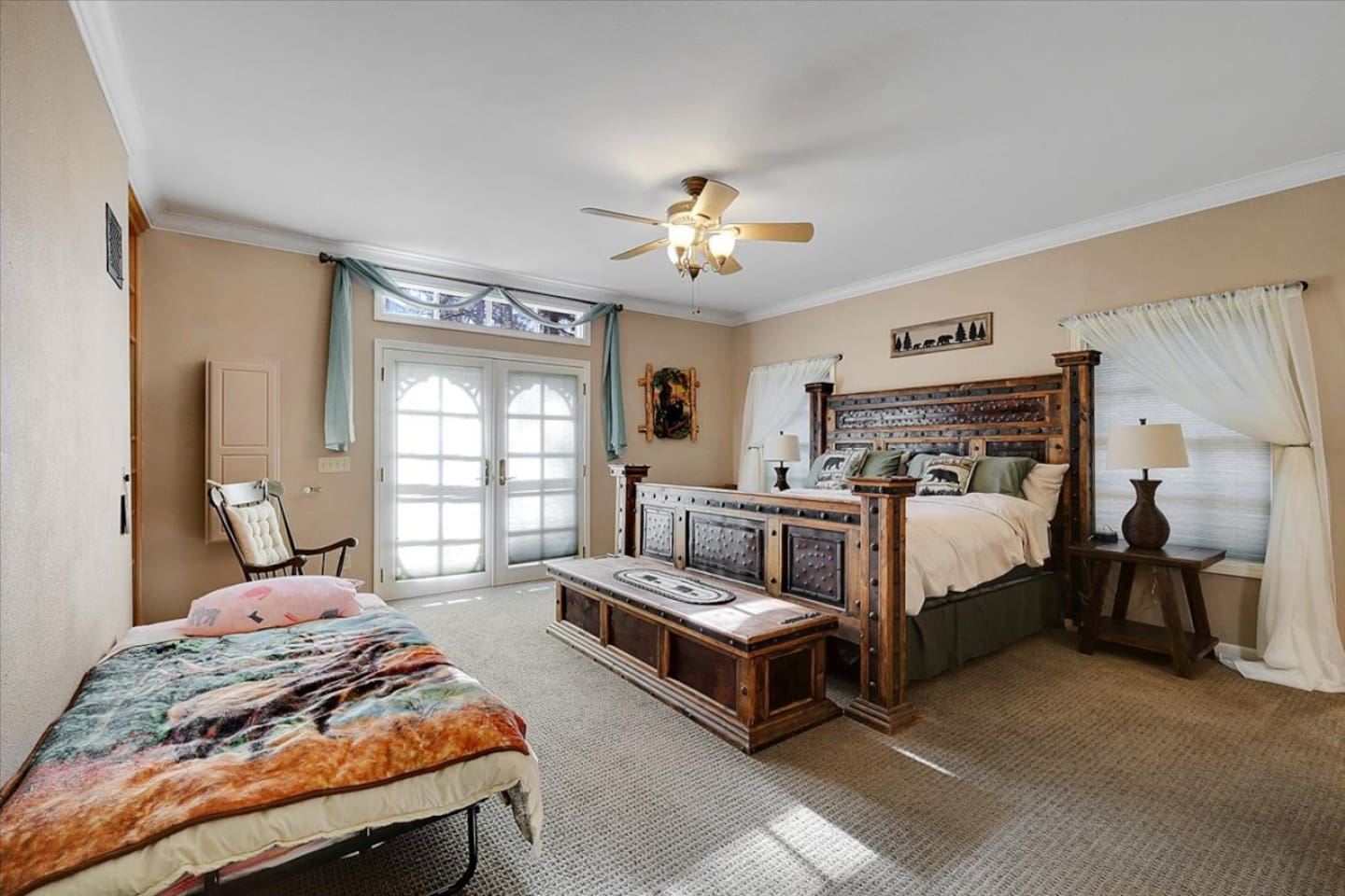 King bedroom with rustic wood furniture, bedside lamps, and a simple place to rest.
