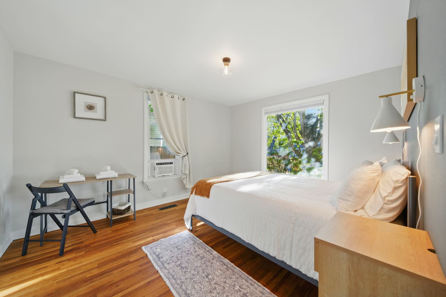 Queen bedroom #1, with dedicated work space/desk & window AC unit, & walk in closet.