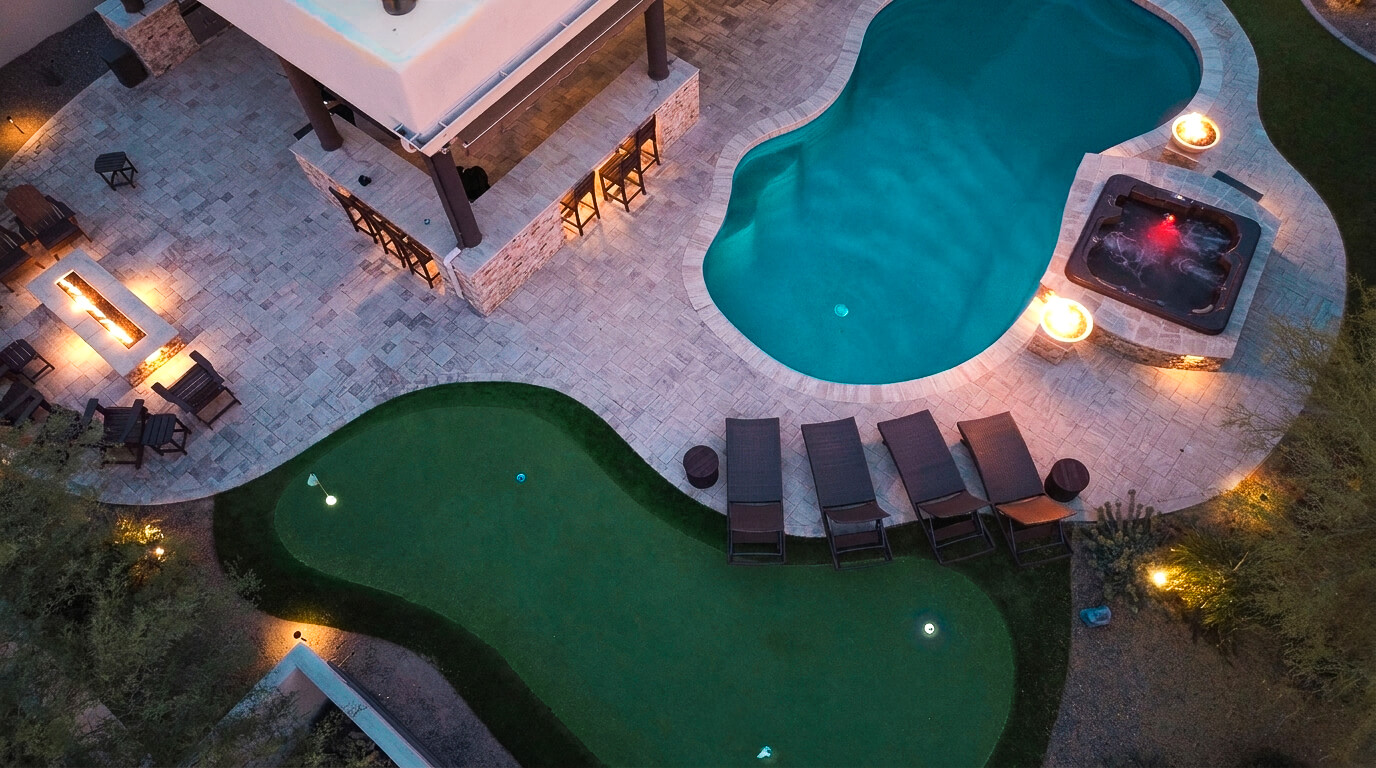 Stunning Night View of Bar Seating, Pool, Spa & Putting Green
