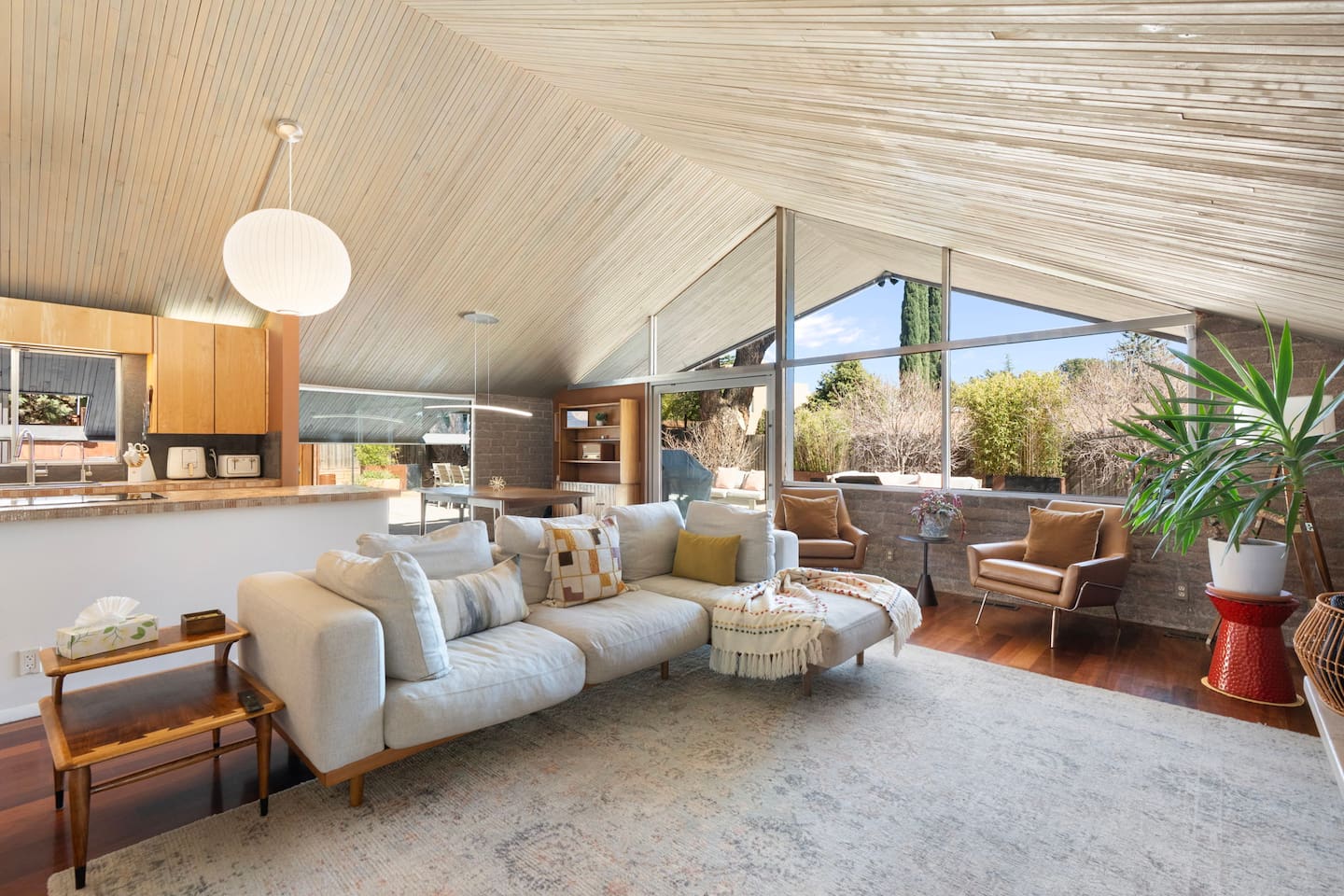 Light-filled great room with vaulted wood ceilings, panoramic windows, and seamless indoor-outdoor living.