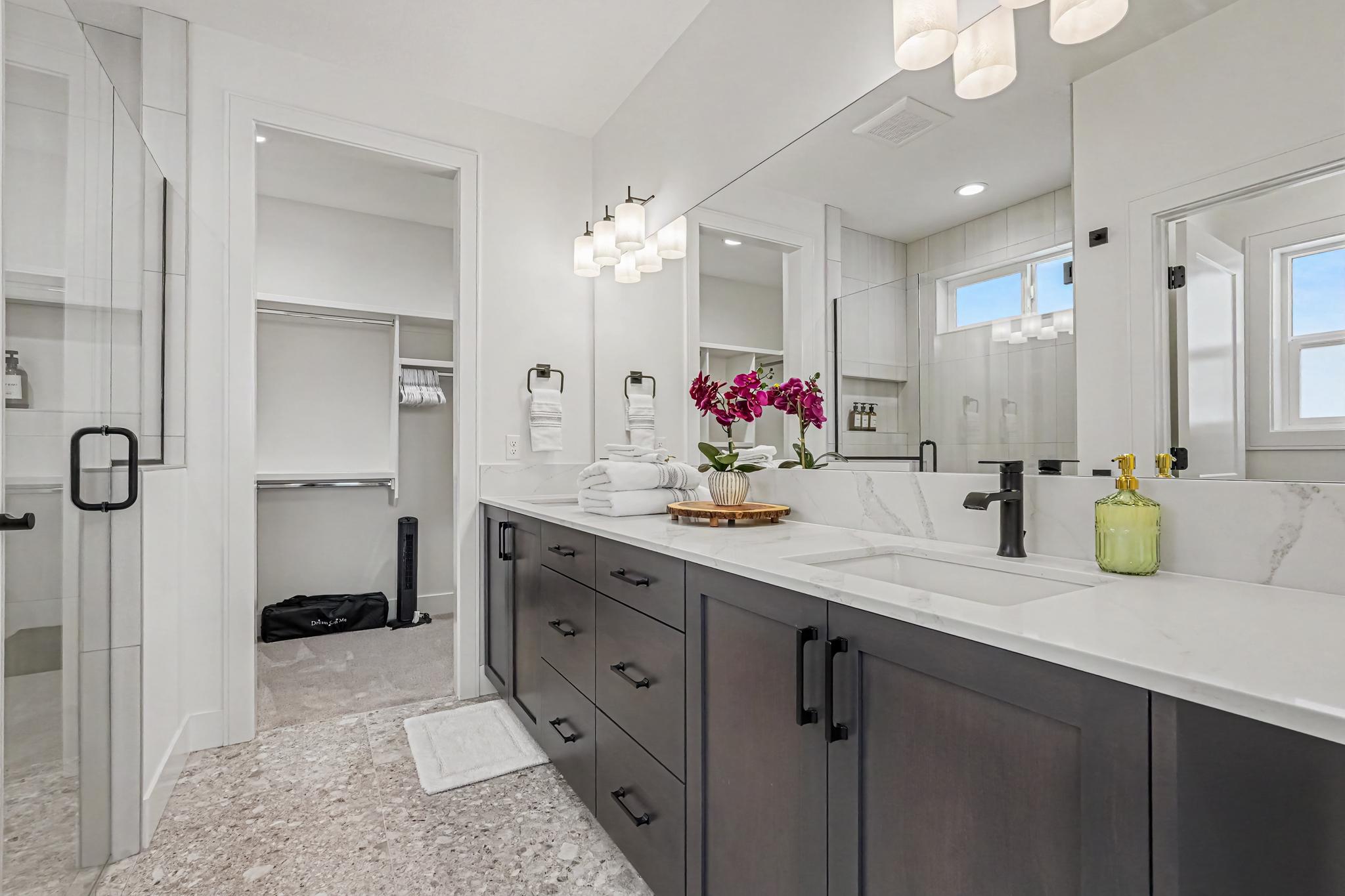Enjoy the luxurious primary bathroom with two sinks, a spacious walk-in shower, and a large walk-in closet with plenty of storage.