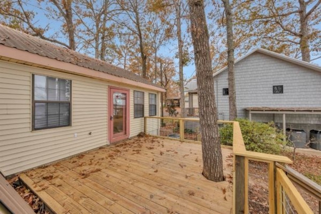 Step out onto the spacious outdoor deck overlooking Toledo Bend Lake, perfect for relaxing and taking in breathtaking views. Just below, by the stairs in the grassy area, you'll find a charcoal grill ready for your cookouts and lakeside gatherings. 