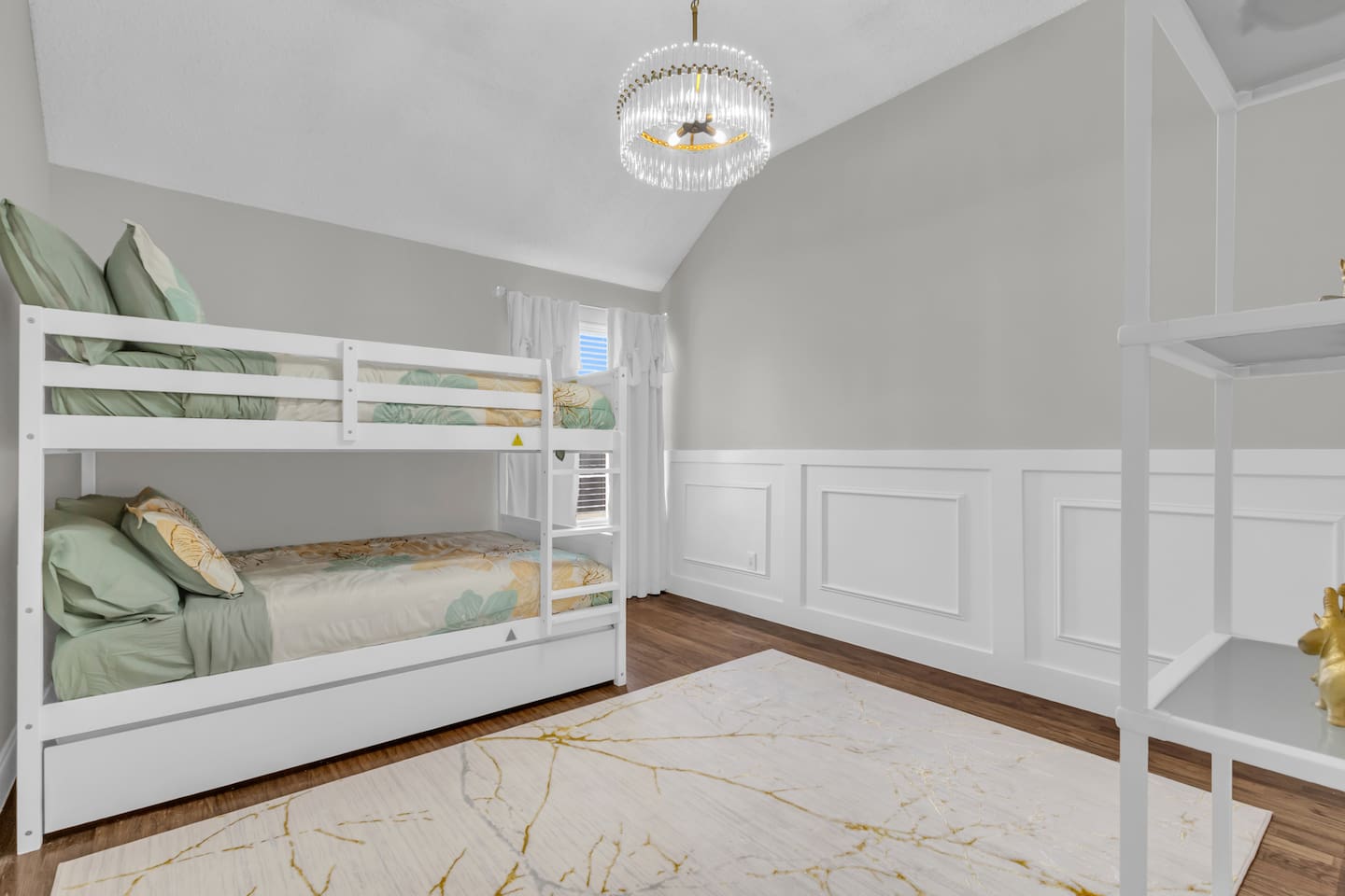Large bunk room with queen-over-queen beds, blackout blinds, ceiling fan, and modern décor designed for families and shared sleeping arrangements.