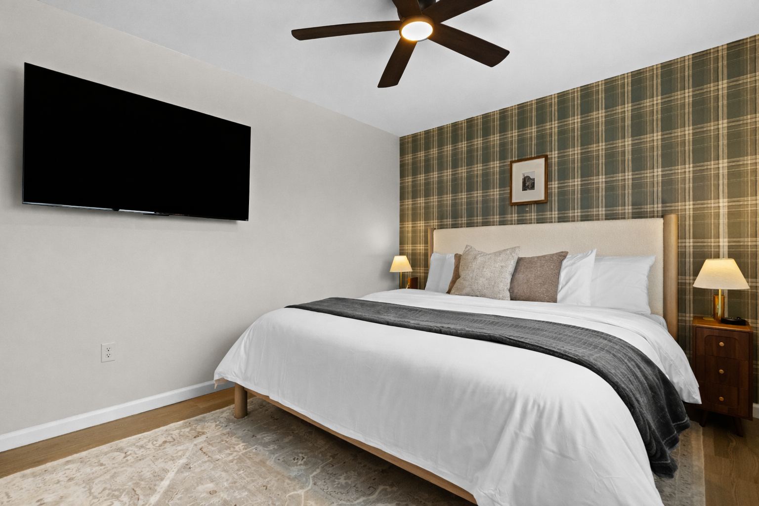 Comfortable bedroom with a plush bed, ceiling fan, and smart TV—calm, stylish, and designed for restful nights and easy
