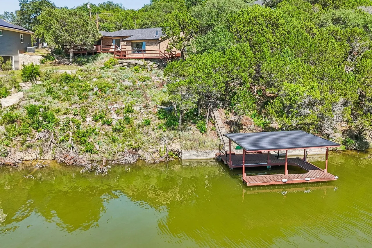 Aerial view showing the home, hillside, and covered dock.