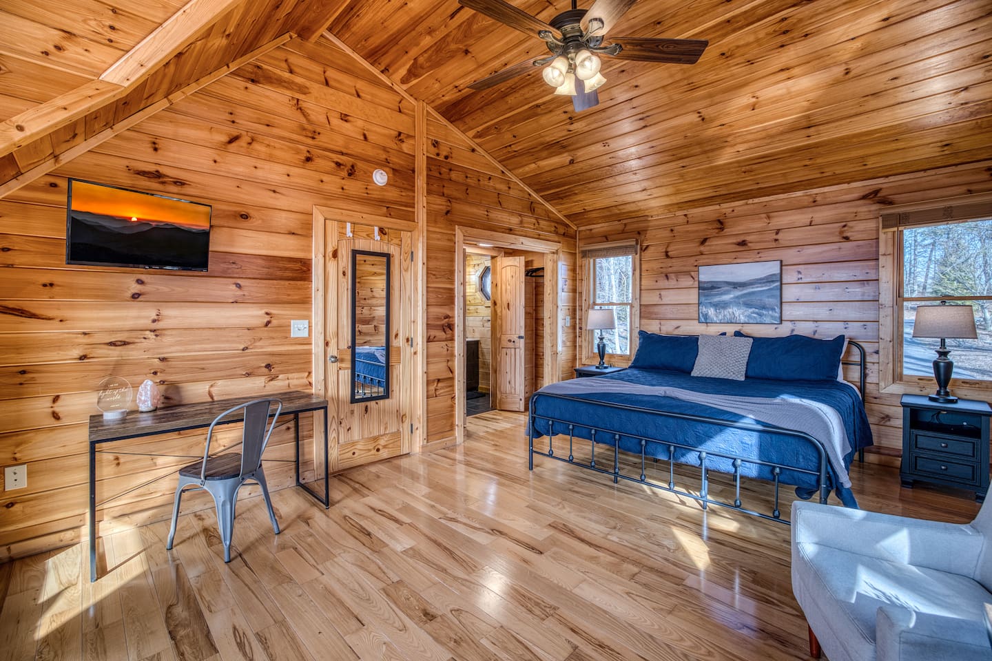 One of the 2 upstairs bedrooms, both with a king bed, private bathroom, and sleeping nook sitting in a huge window with stunning mountain views!