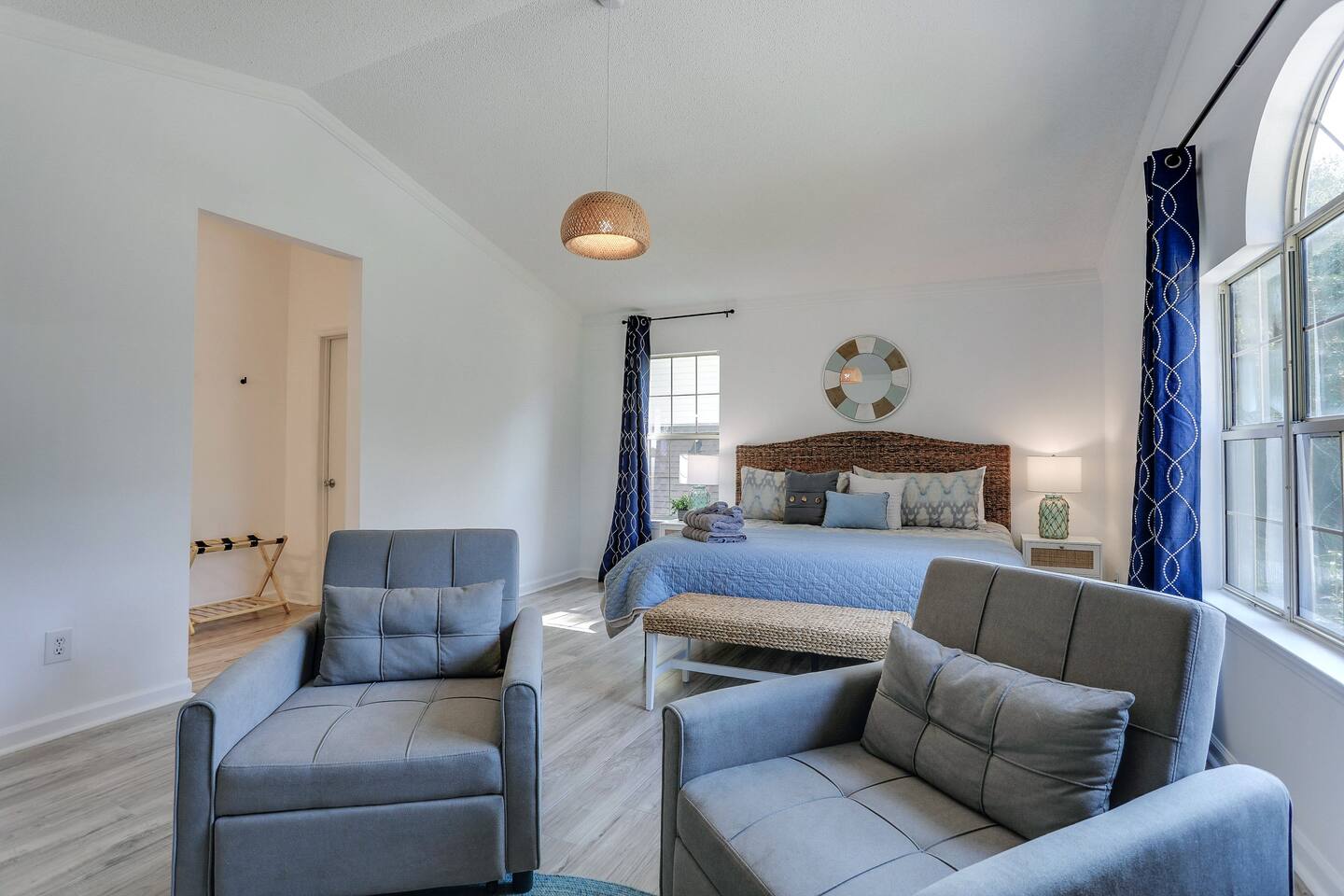 The primary bedroom at is a relaxing retreat, complete with a luxurious king-sized bed, a smart TV for your entertainment, an ensuite bath for added privacy, and two cozy side chairs, perfect for unwinding after a day of exploring.