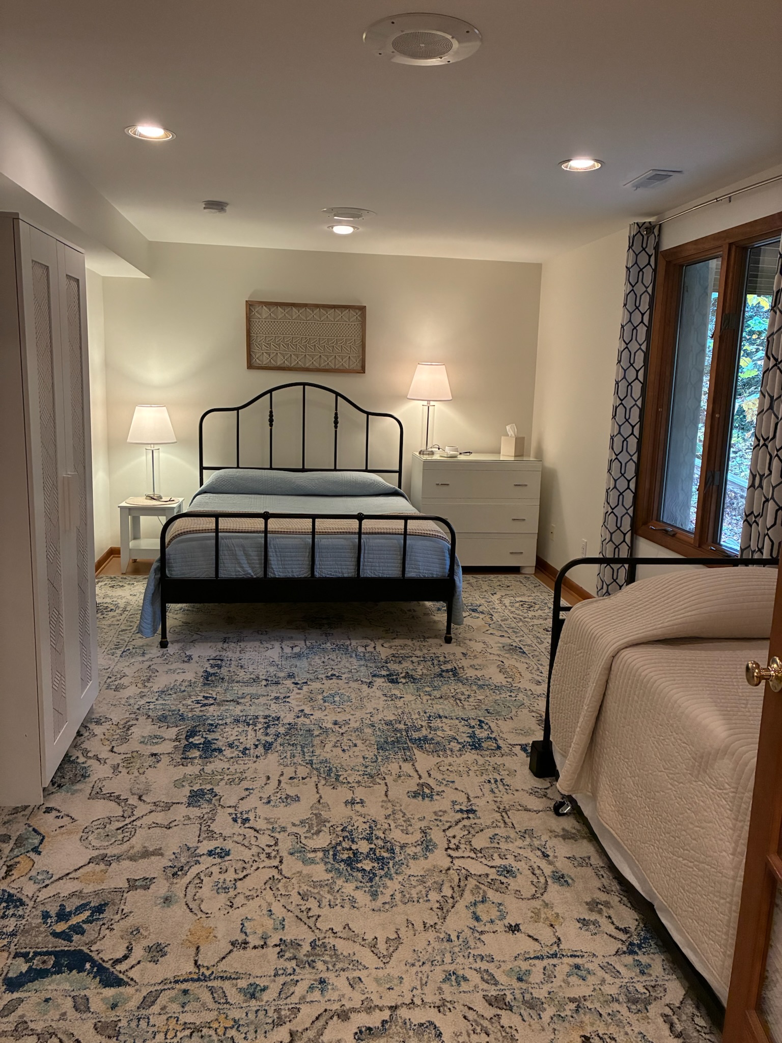 Bedroom has a queen bed, dresser, free-standing closet and trundle bed.