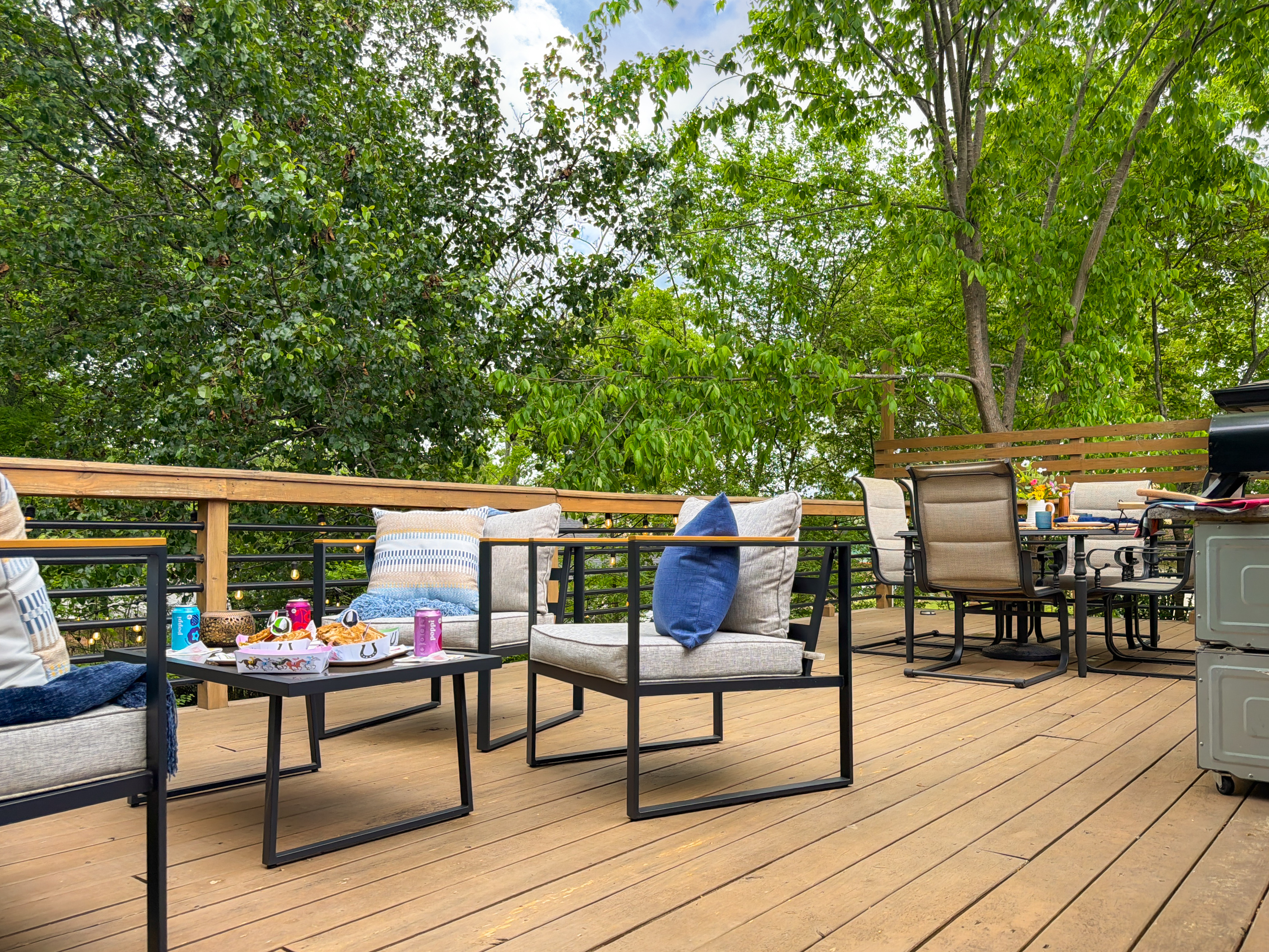 Take the whole party out to the upper deck — two seating areas under the trees, drinks poured, and nobody in a hurry to head back inside.