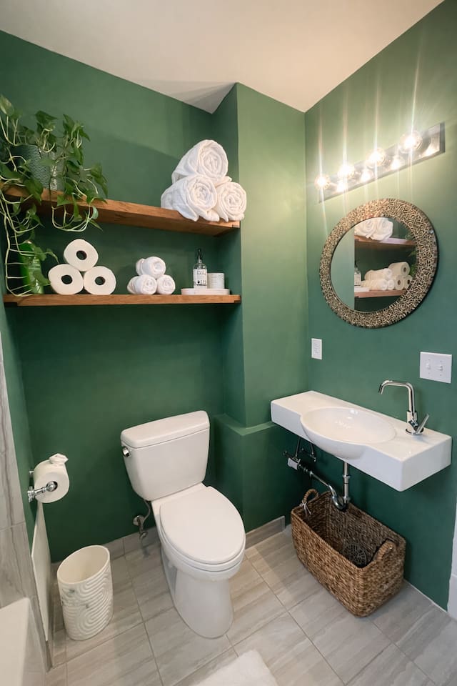 Stylish bathroom with green accent walls and contemporary design.