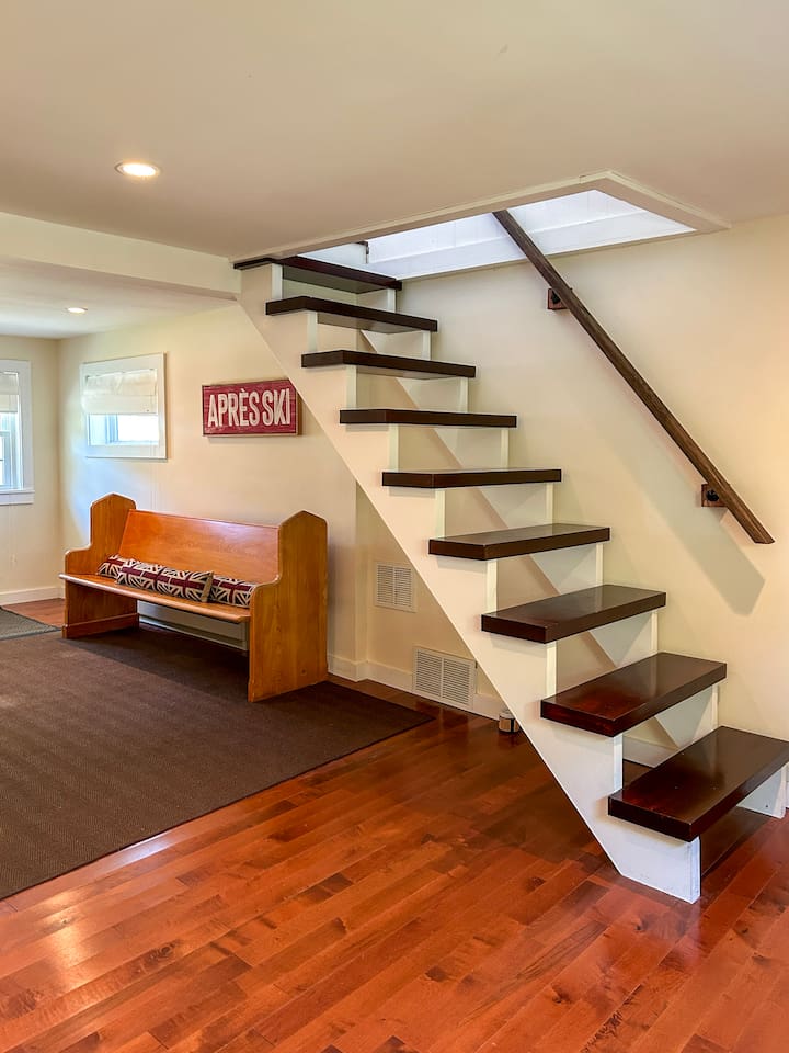 Entryway and stairway leading up to the primary bedroom suite. Please note that the stairs are open on one side, so young children should not go up or down the stairs without an adult. 