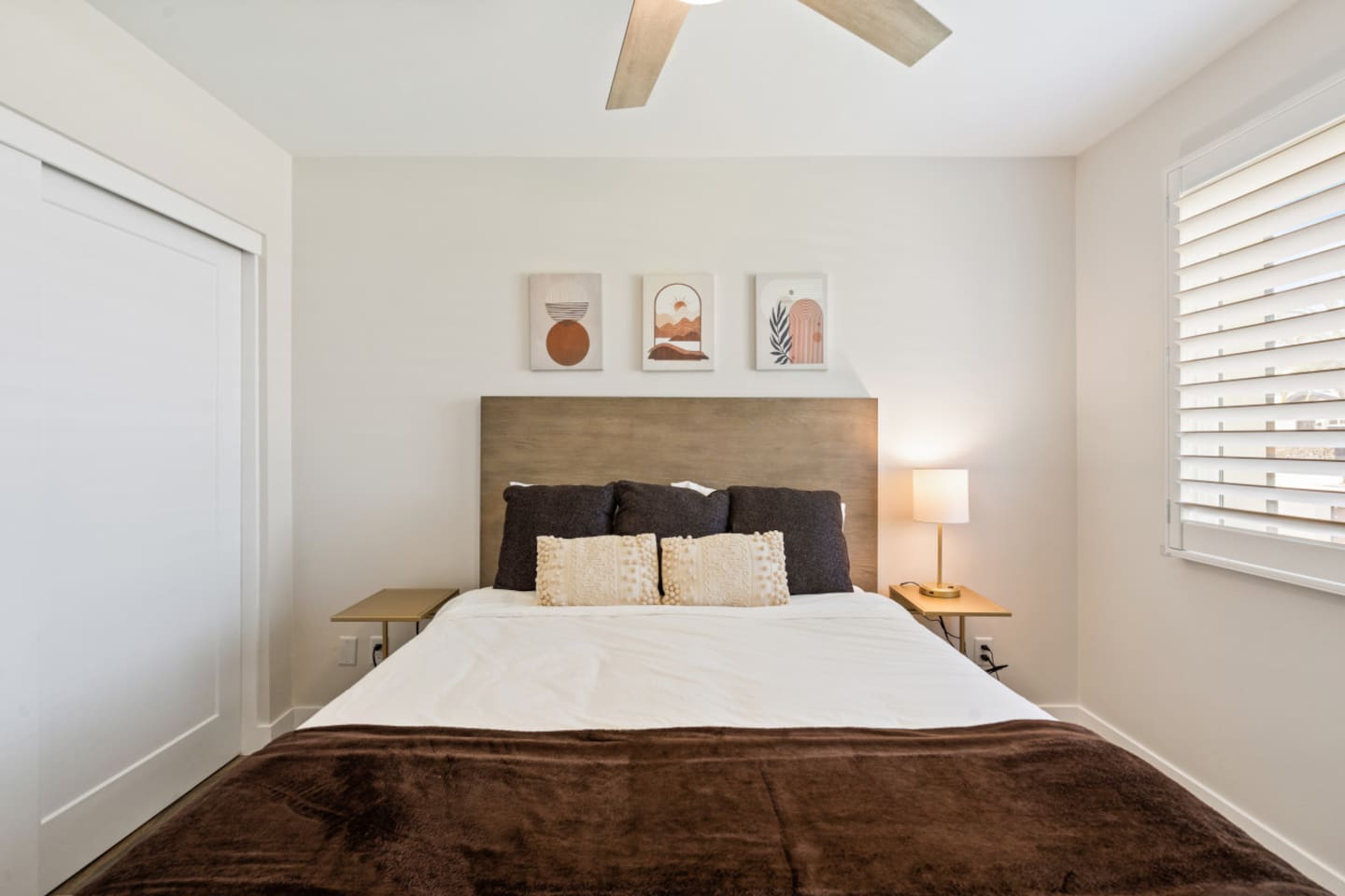 Guest bedroom with a queen bed, bedside lighting, ceiling fan, and closet storage for a comfortable stay.
