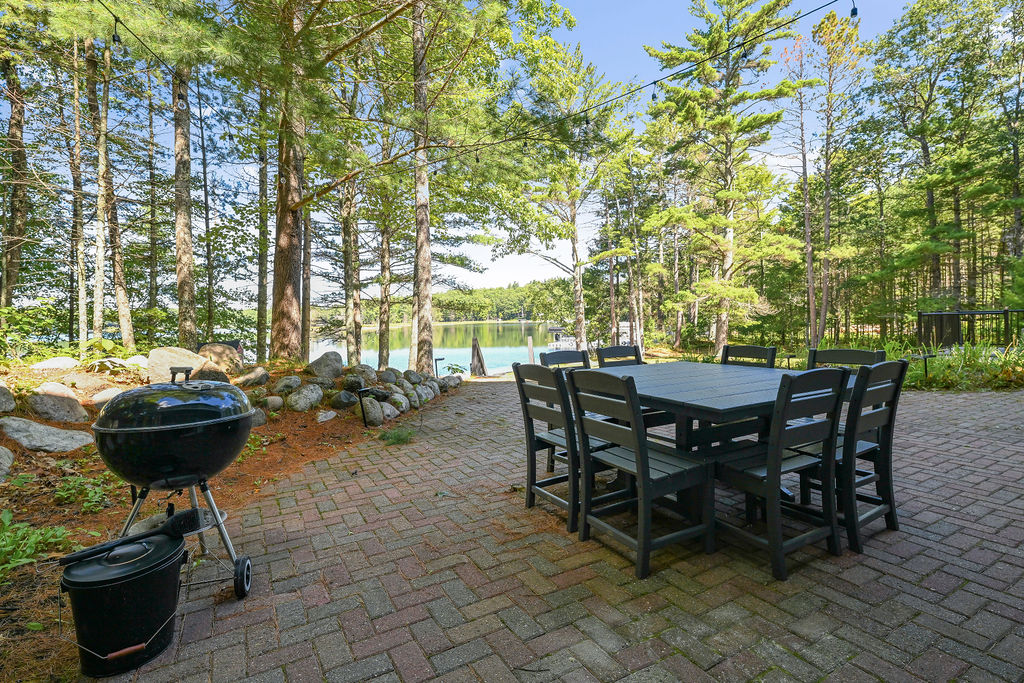 Patio, charcoal grill, and outdoor dining table (seats 8) with string lights overhead