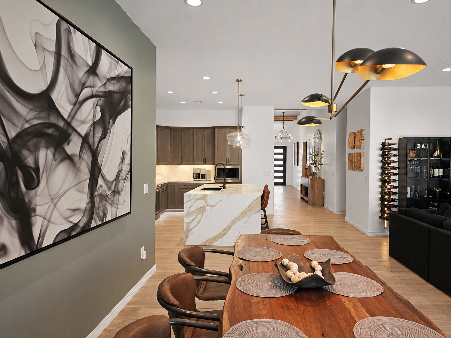 A dramatic Restoration Hardware light fixture hangs above the dining table, creating a sophisticated focal point.