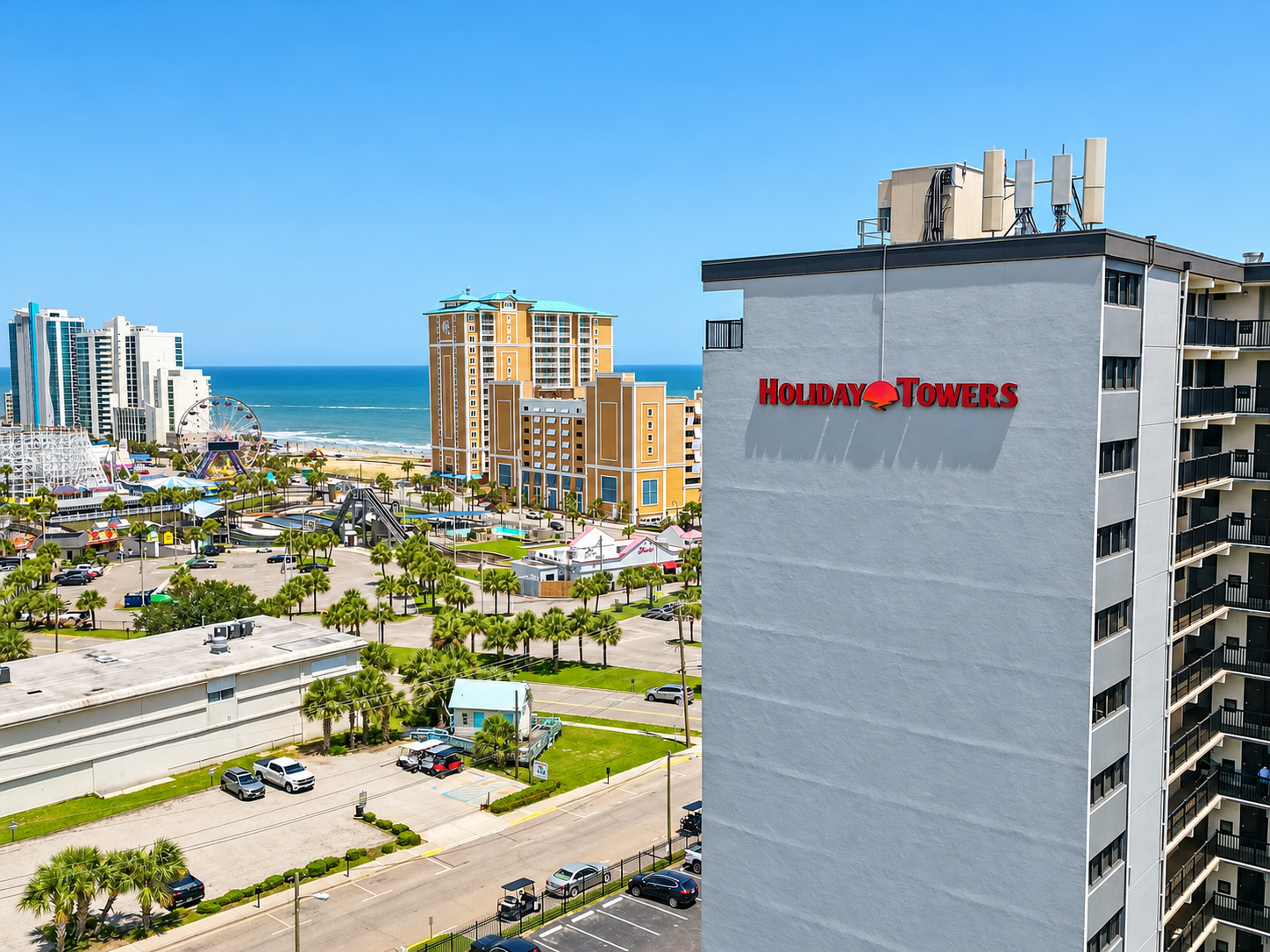 Holiday Towers exterior with ocean views nearby and Myrtle Beach attractions just across the way.