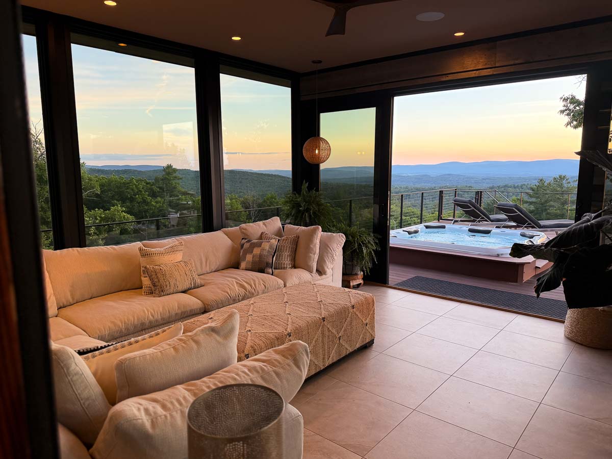 Evening sunroom at Sunset Falls looking out to the hot tub and deck lounge chairs &mdash; Berkshires