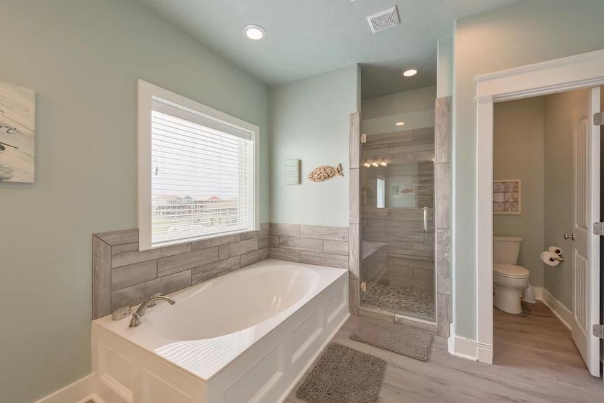 Breezy Point Bathroom 3: Elegant ensuite connected to Bedroom 4 with a soaking tub, walk-in shower, and dual sinks.