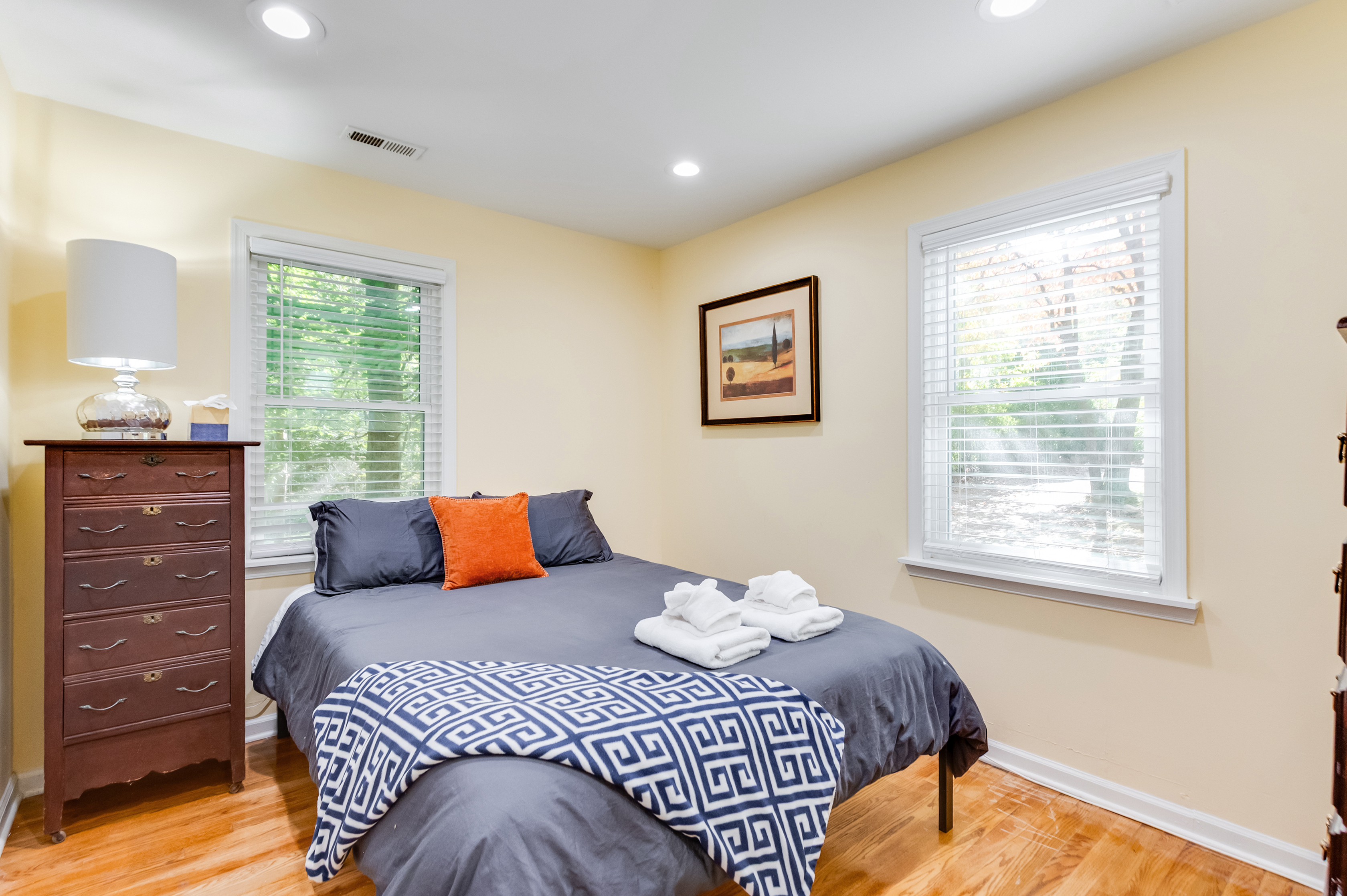 Upstairs Queen Bedroom 1: Relax in a sunlit space with plush bedding and charming decor!