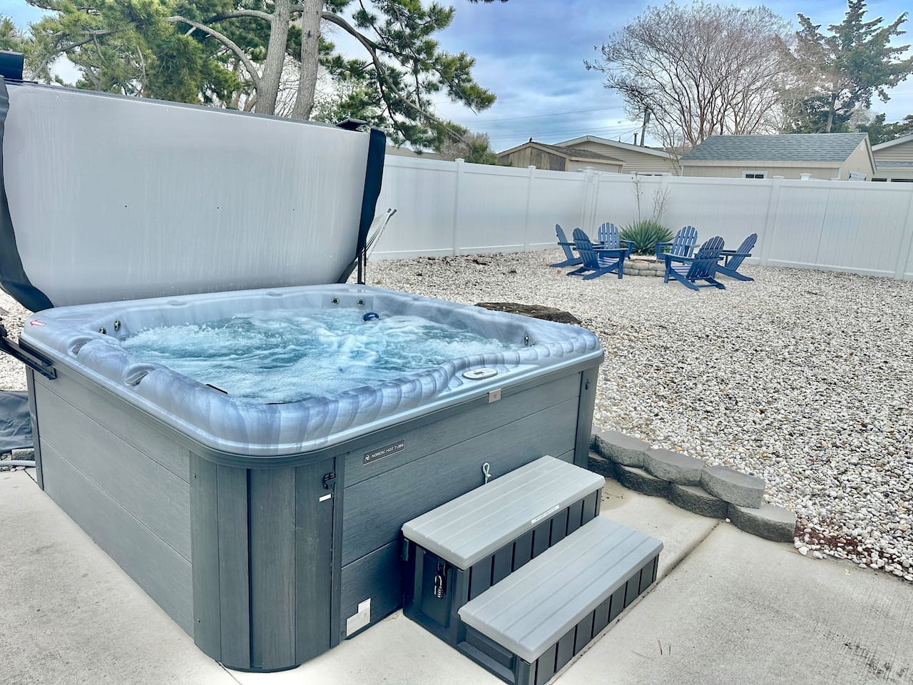 Unwind in our private hot tub, perfectly situated for stargazing. The fenced backyard also features a gravel lounge area with Adirondack chairs—the ultimate spot for evening relaxation and fresh air.