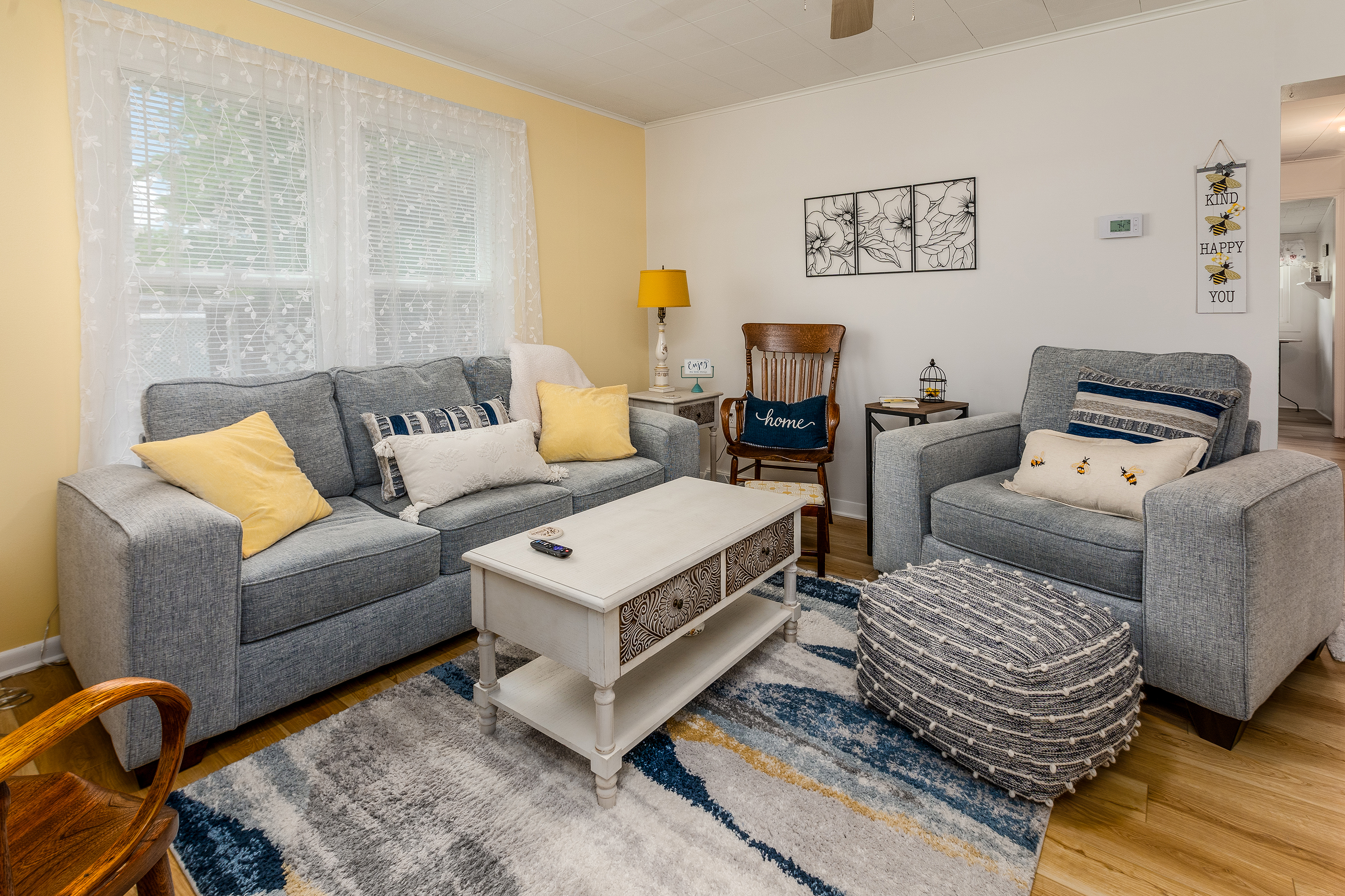 This cheerful living room is filled with honey-hued touches, cozy seating for everyone, and a 32" smart TV for your favorite shows. Whether you're sipping coffee, reading by the bookcase, or relaxing in a rocker—this space is bee-yond cozy!