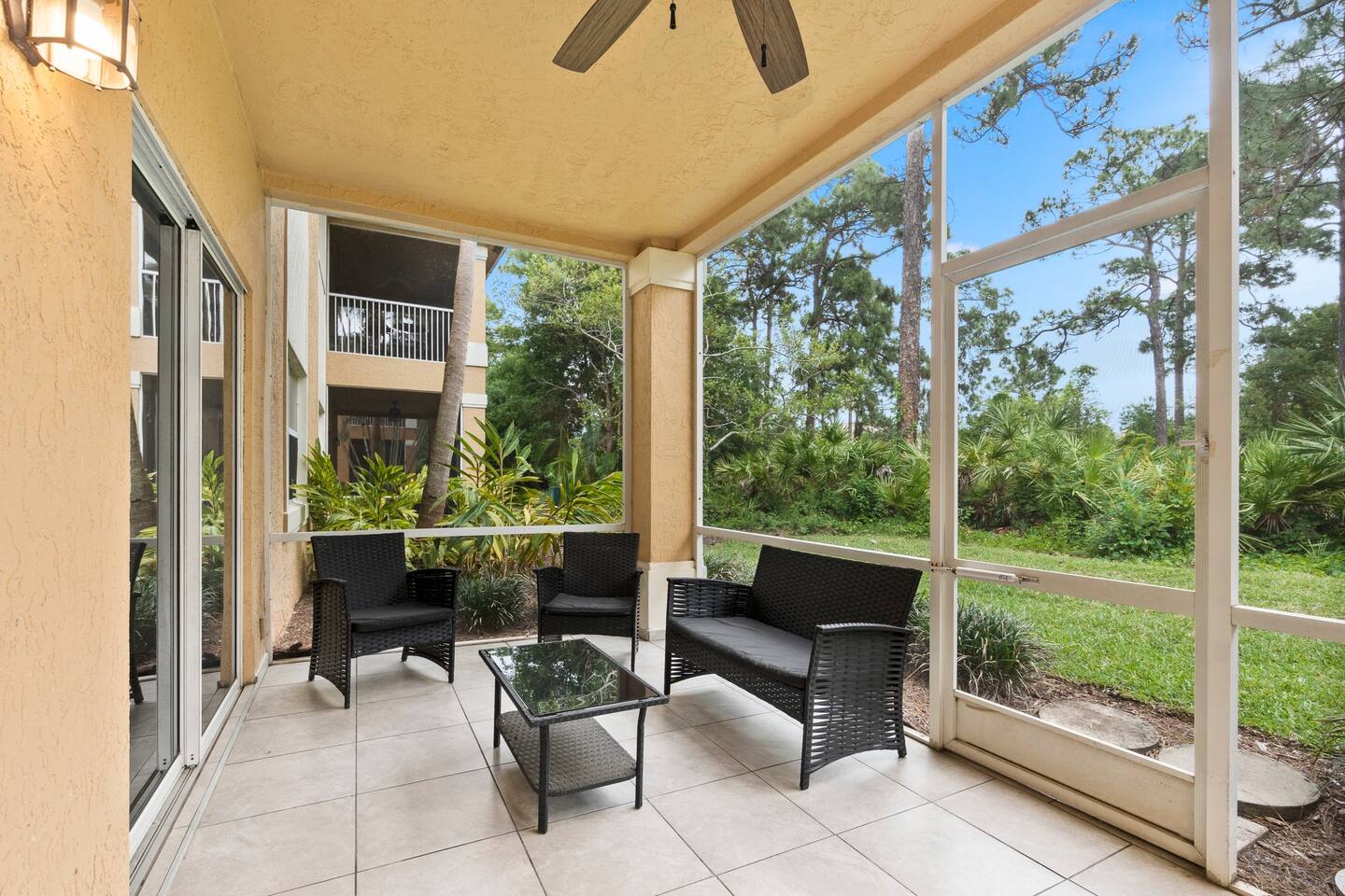 Private screened patio with comfortable outdoor seating and peaceful views of the surrounding landscaping.