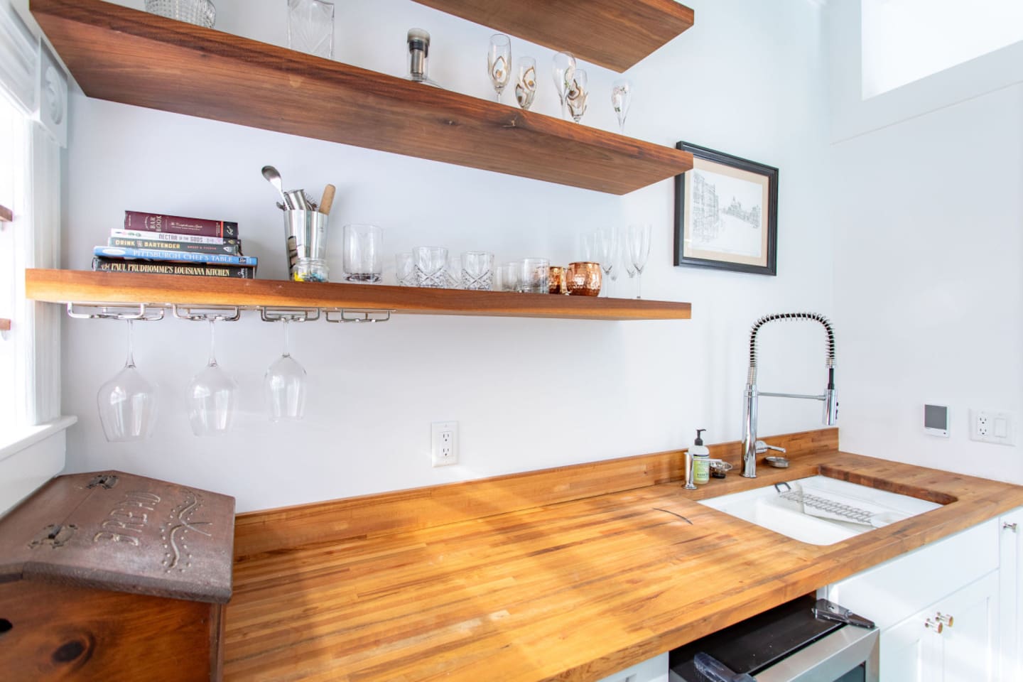 A sleek kitchenette sink, perfectly integrated into the counter with modern fixtures, providing a practical space for washing dishes or preparing food in a compact kitchen.