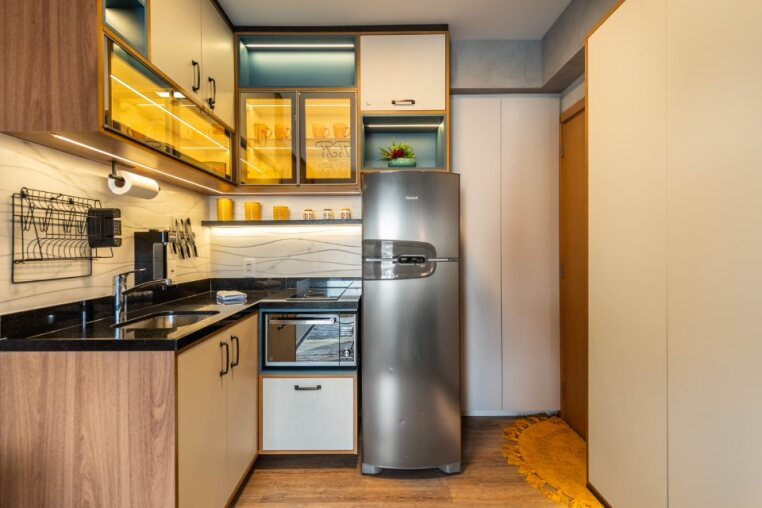 Cozinha planejada com geladeira, cooktop, micro-ondas, cafeteira, filtro de água e utensílios — ideal para estadias curtas ou longas em São Paulo.