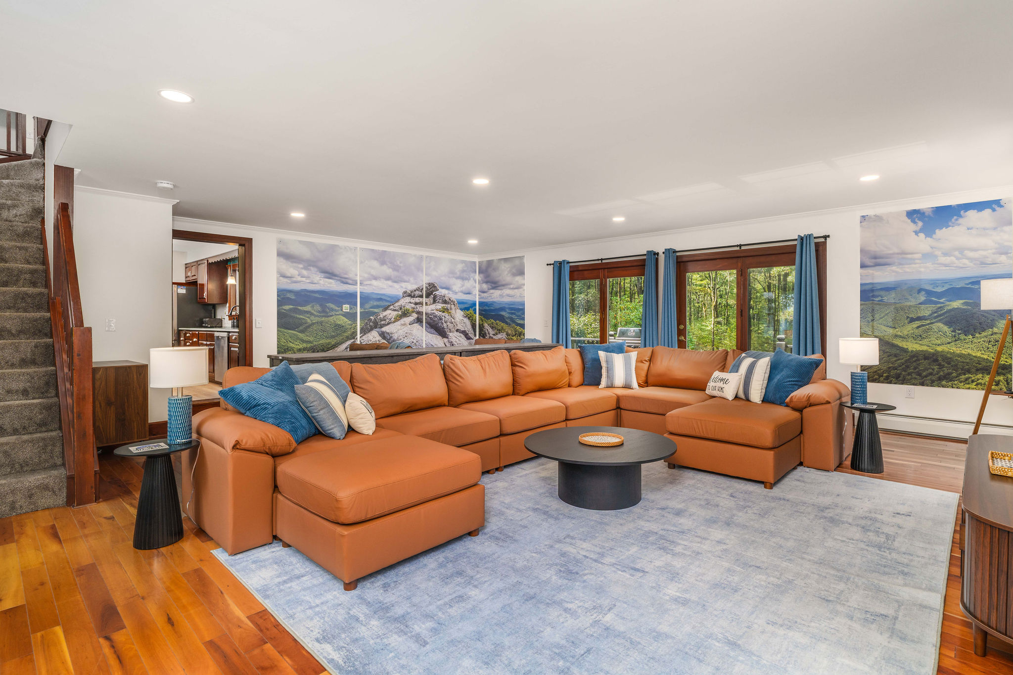 🛋 The main living room: sectional seating for 6, 65" HDTV, electric fireplace, and floor-to-ceiling mountain imagery.