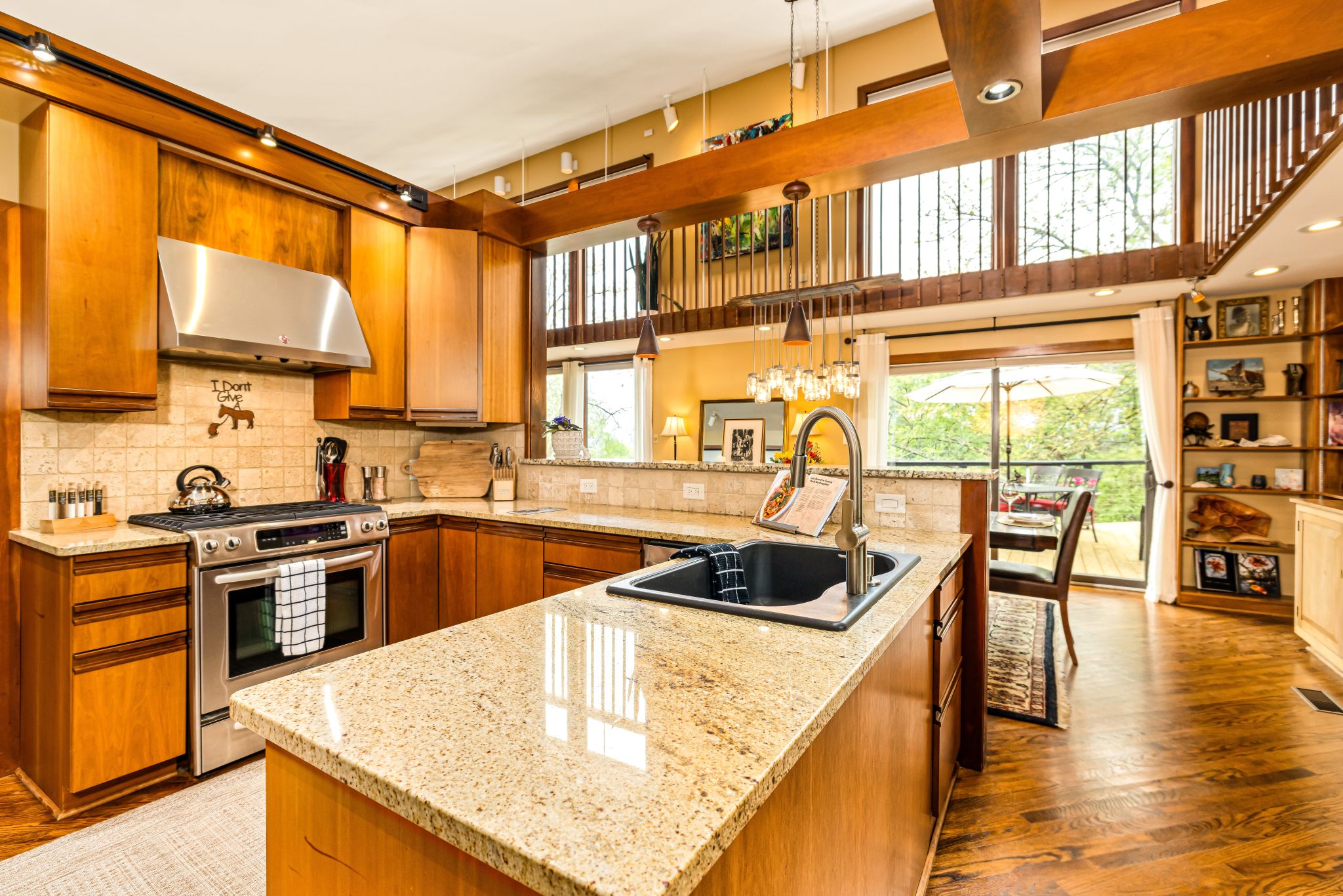 Hilltop Oasis Abingdon's fully equipped chef's kitchen with a gas stove, stone peninsula, and two-story windows. Open to the dining area to easily connect with family and friends. Enjoy local Abingdon Olive Oil options.