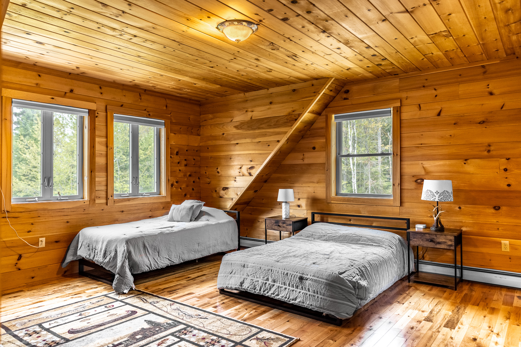 Enjoy another full suite upstairs with a full and 2 twin beds, full bathroom with large closets, charging station by your bed, TV for streaming, and all with lake views.