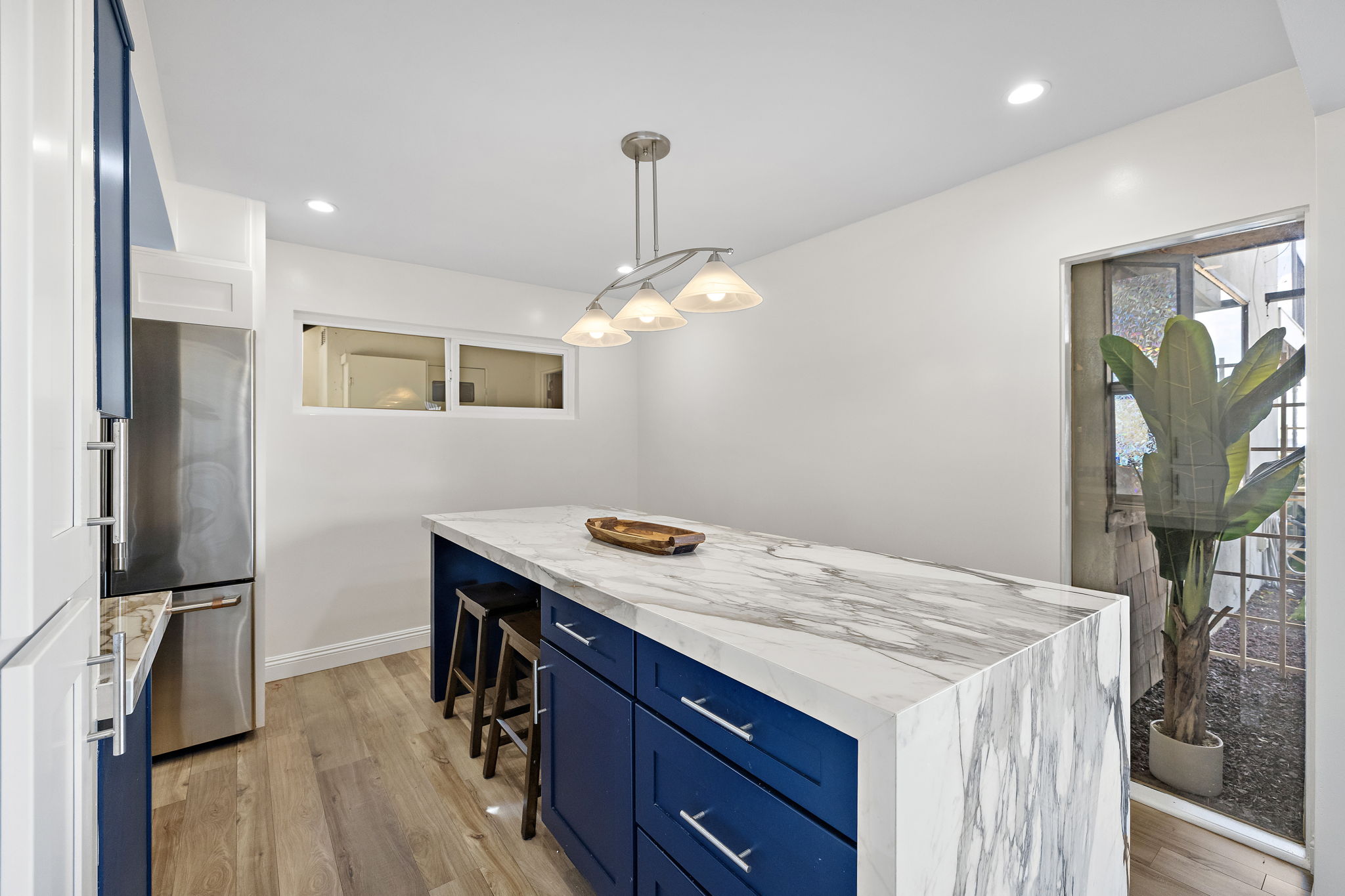 Bright dining area featuring seating for six around a stunning marble kitchen island