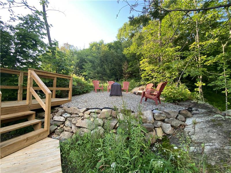 Firepit area behind cottage on hill.