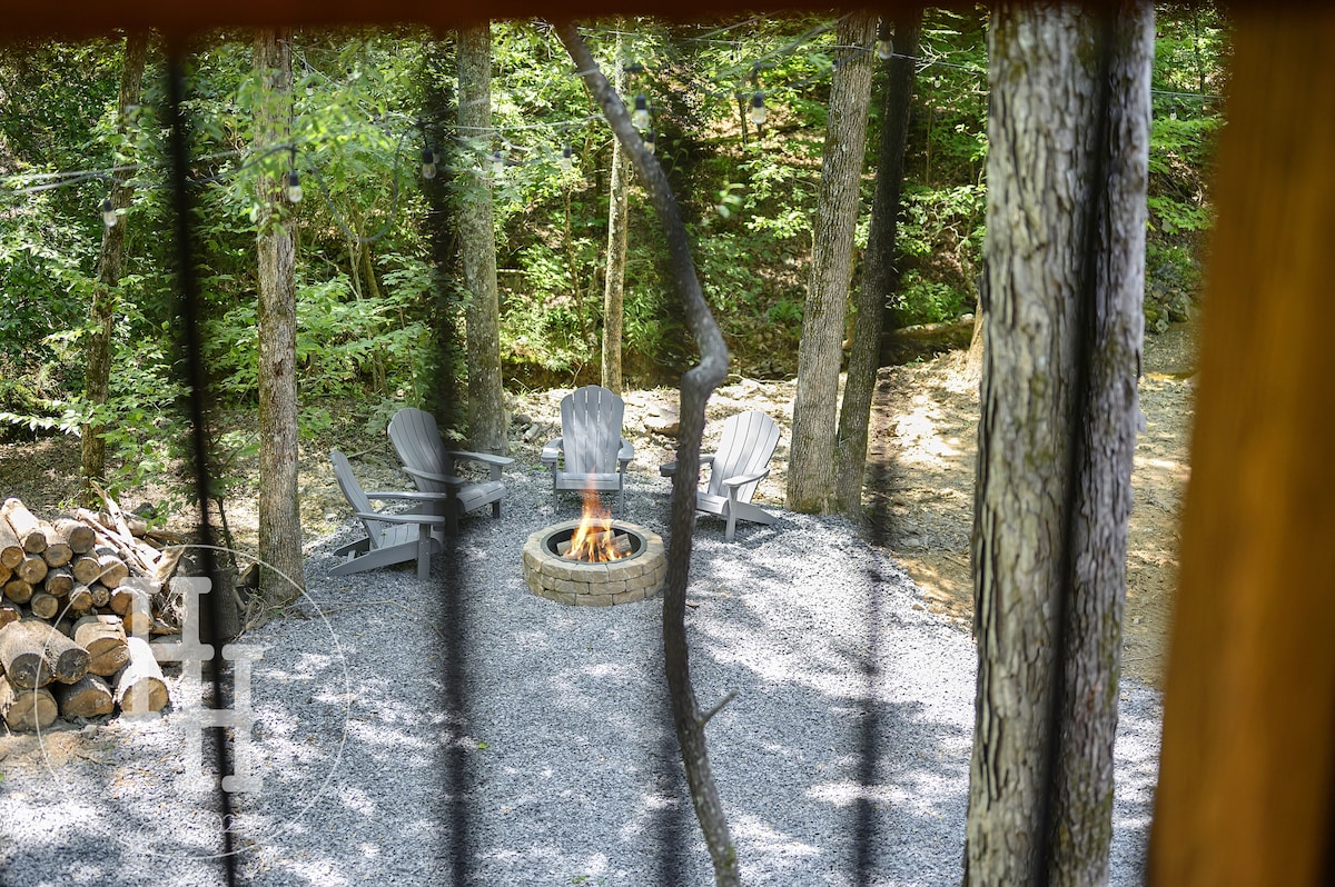 View of the creekside firepit with six chairs, smore's sticks